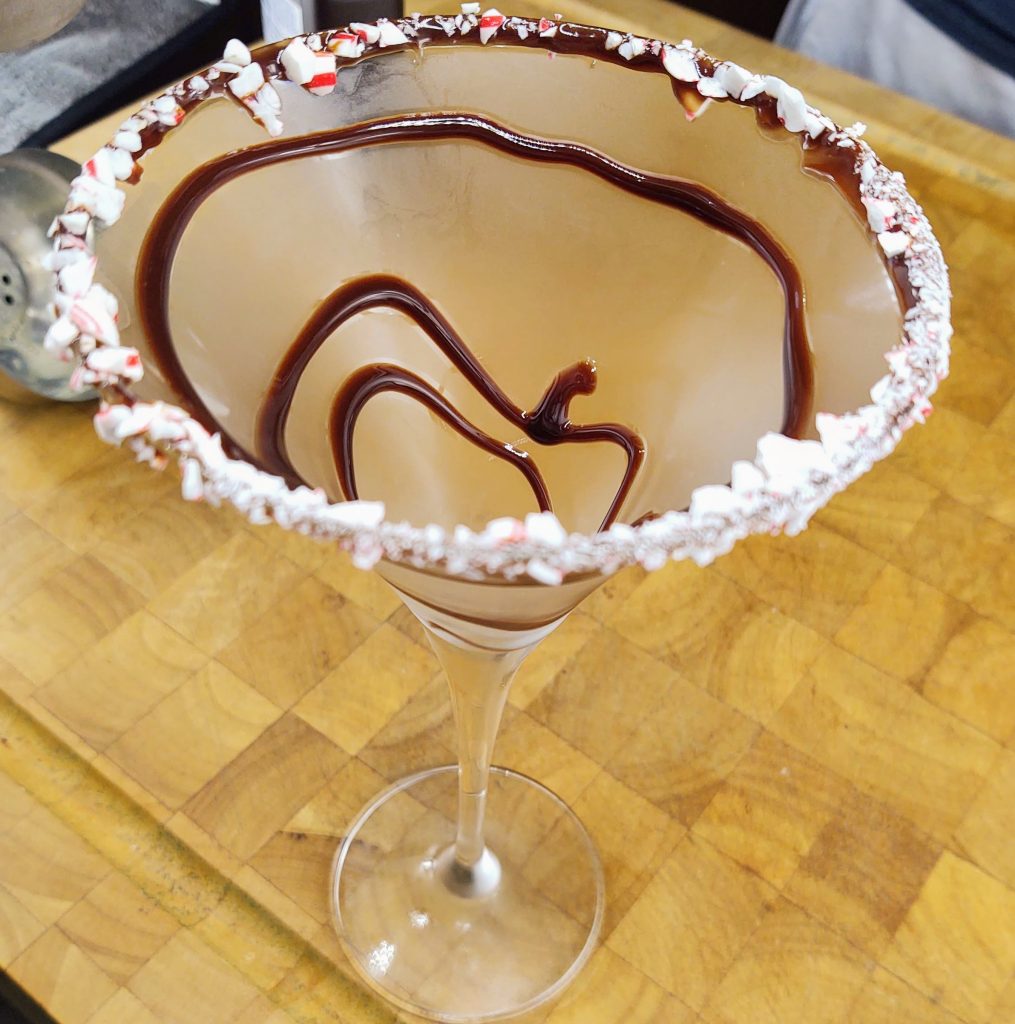 martini glass rimmed with candy cane and chocolate swirl