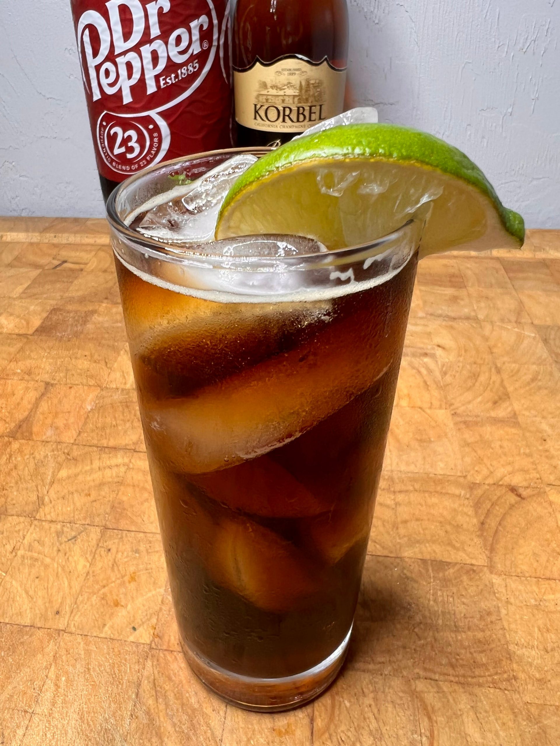 brandy and dr pepper in glass with lime on rim