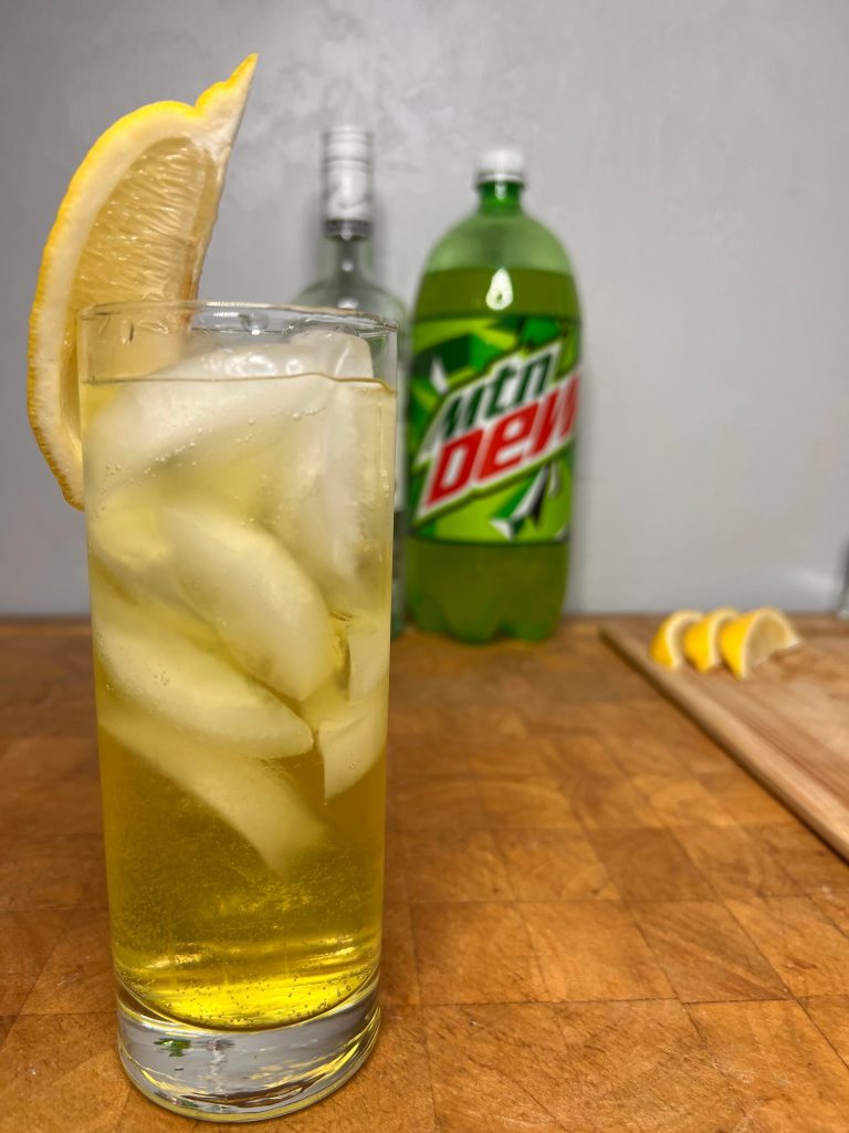 close up of rum & mountain dew with liquor bottles visible in the background