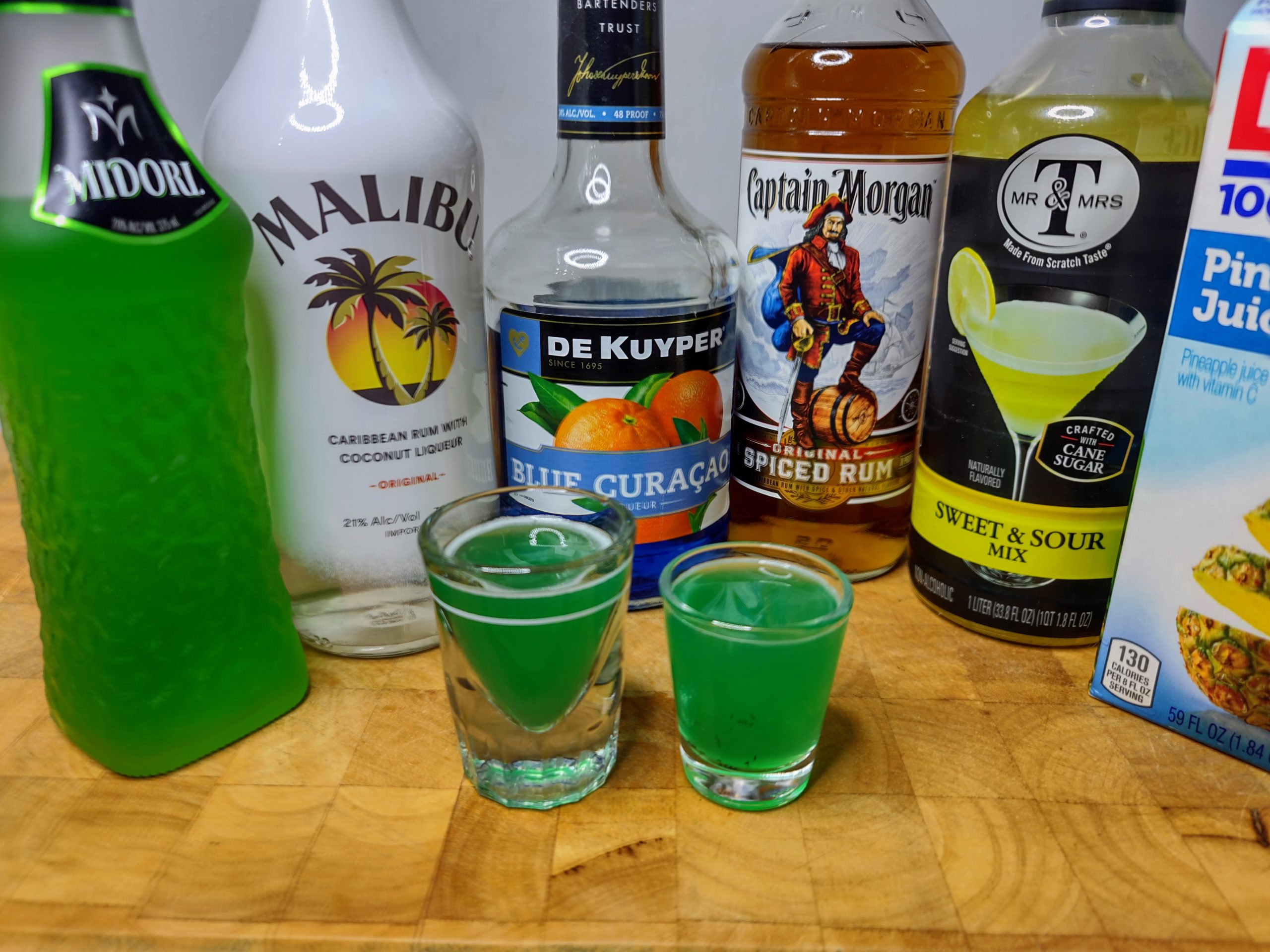 two liquid marijuana shots with ingredients in the background
