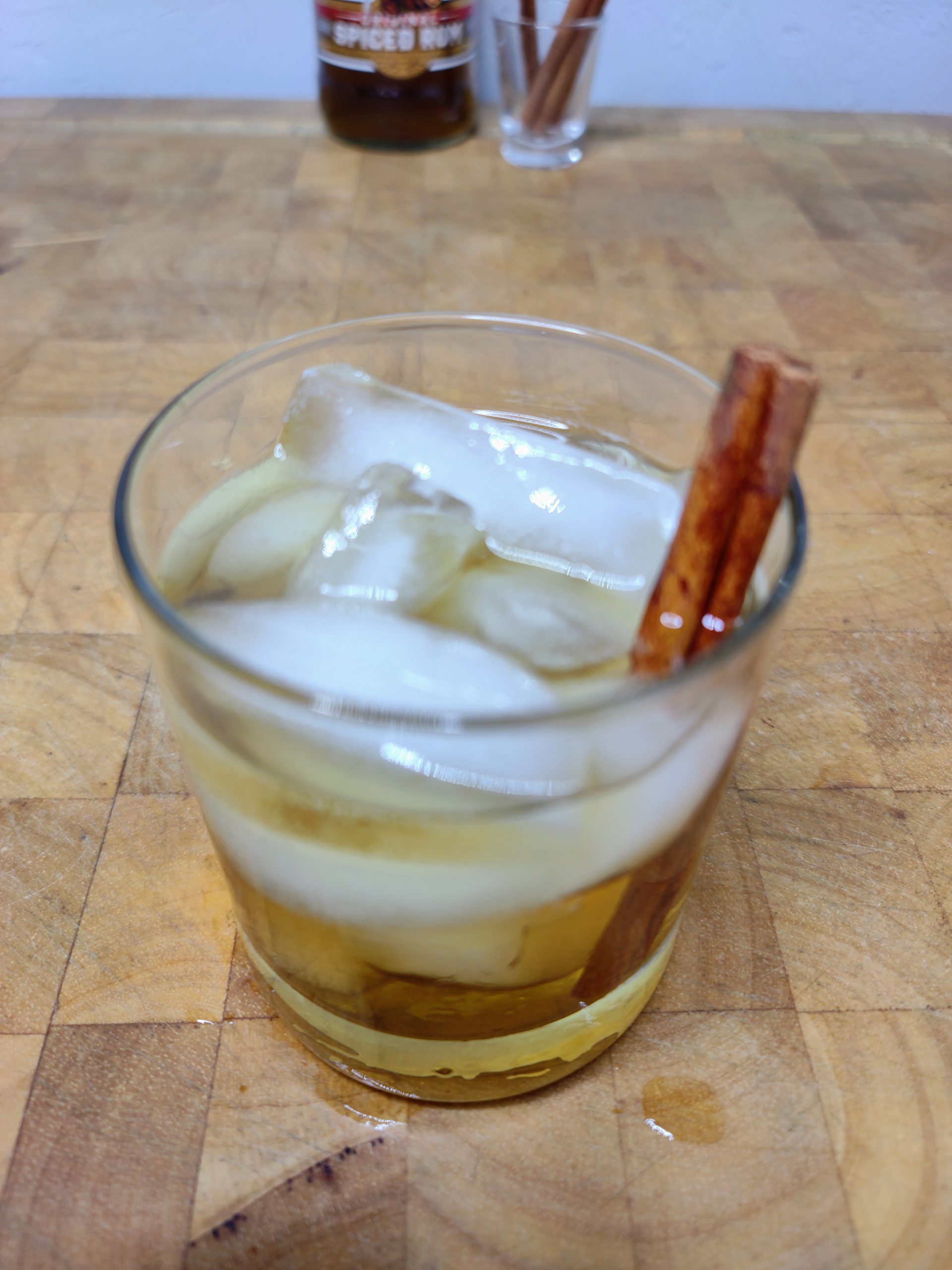 glass of rum and apple juice with a cinnamon stick
