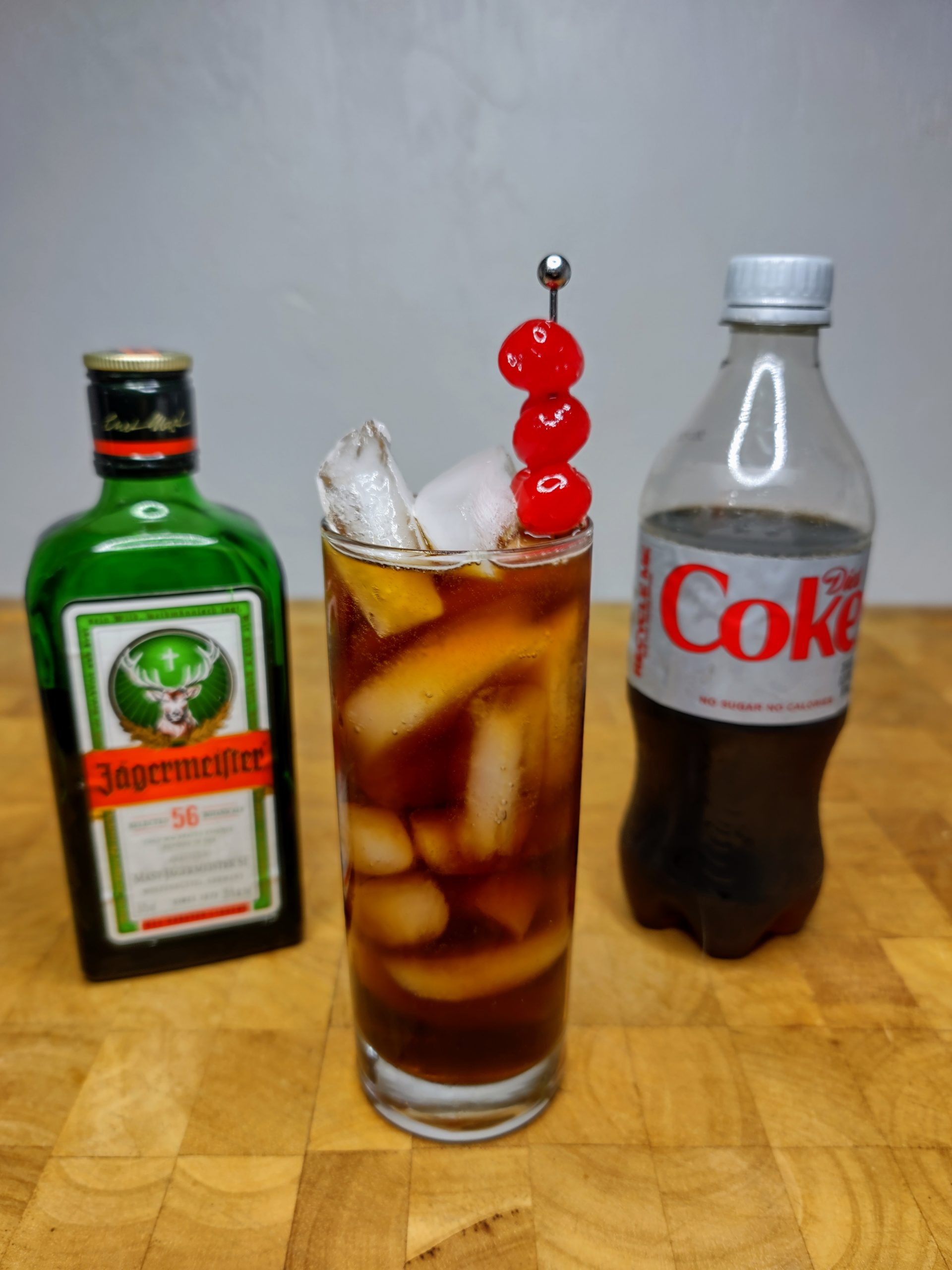 jager and coke in a glass with ingredients next to it
