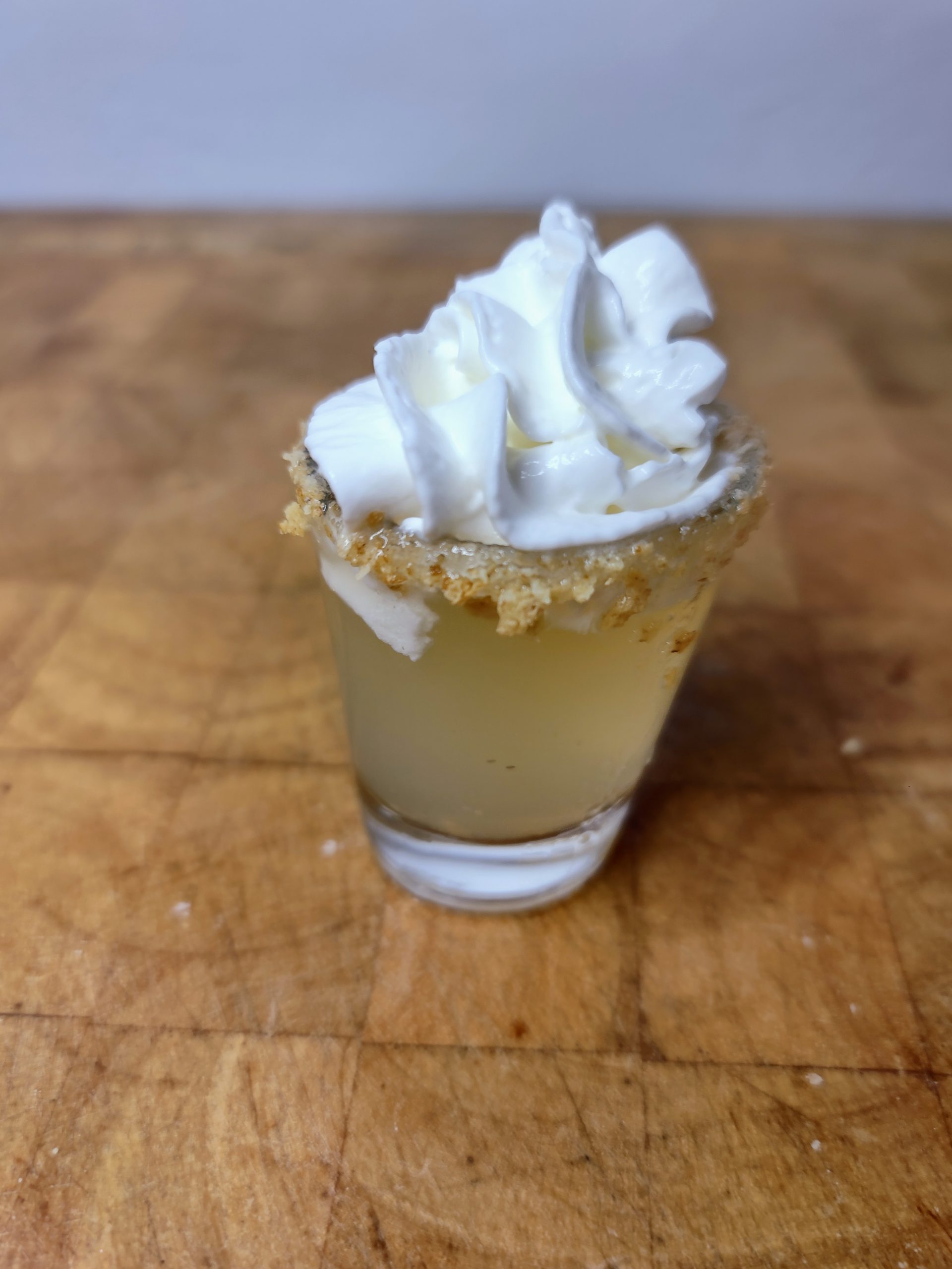 closeup of key lime pie shot on a wooden table