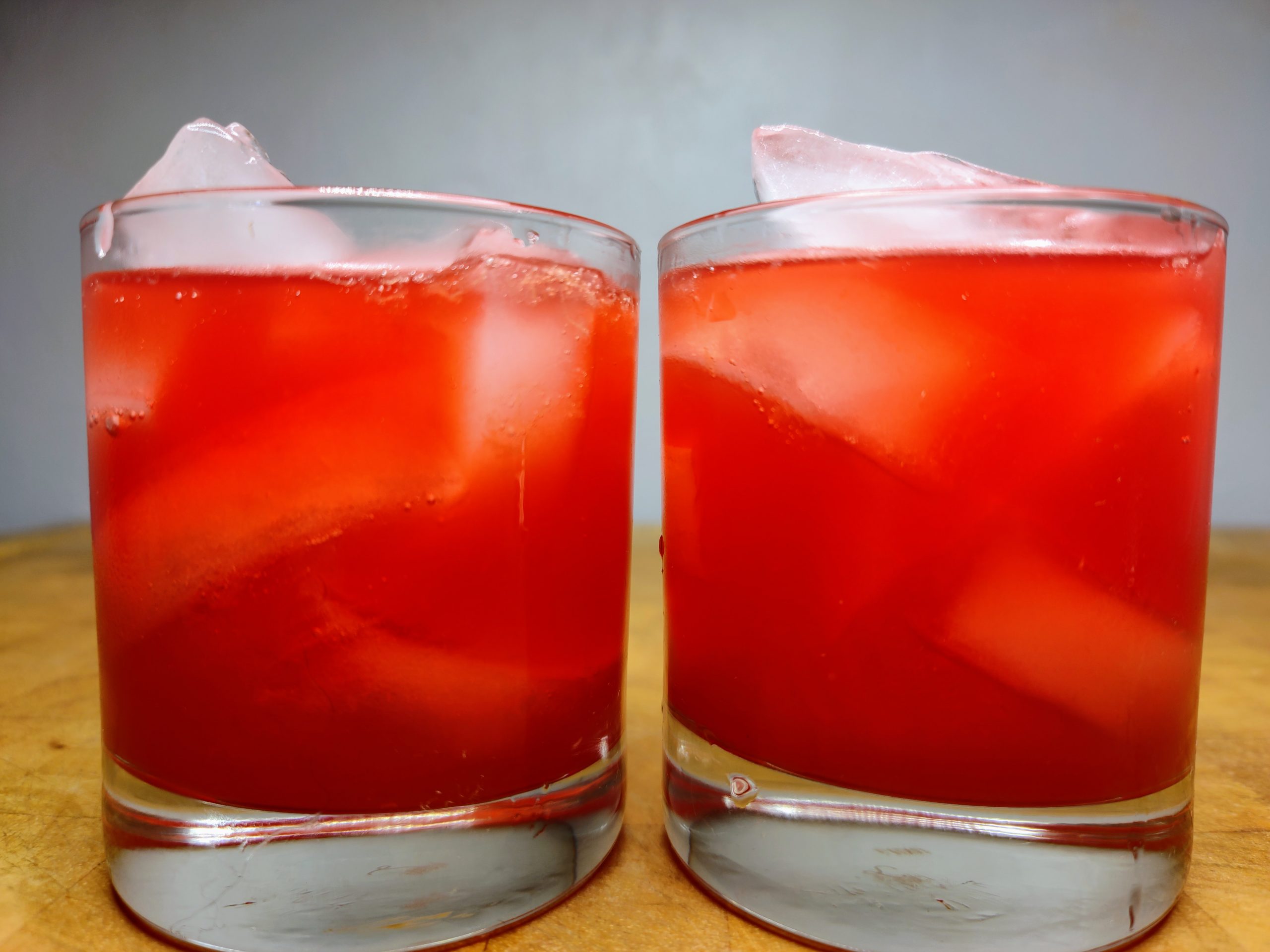 two red devil drinks on a wooden table