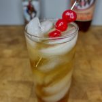 rum and cream soda in a glass with cherry garnish