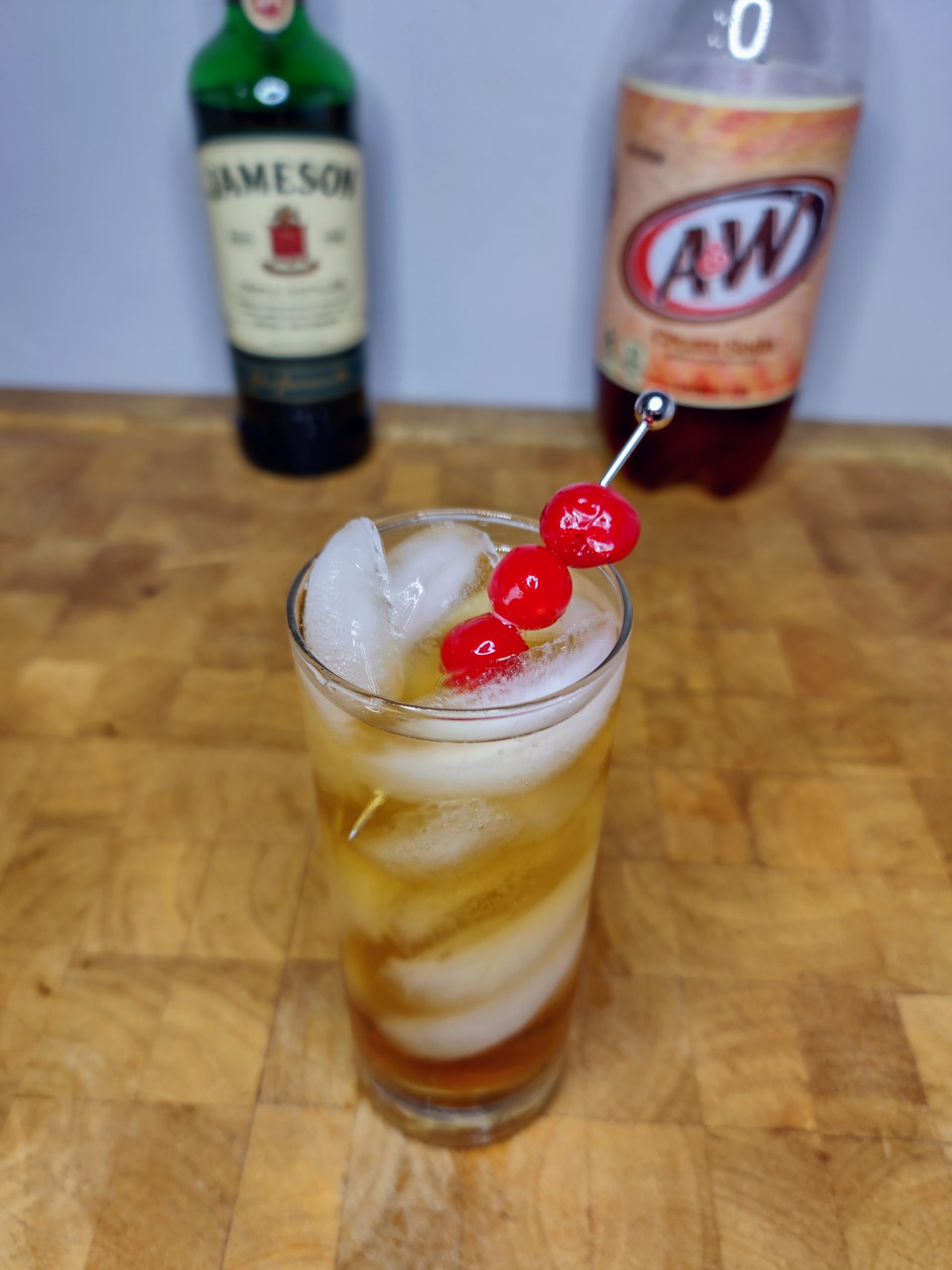 whiskey and cream soda in a highball glass with ingredients behind the drink