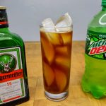 mountain dew and jager mixed in a highball glass with ingredients next to the glass