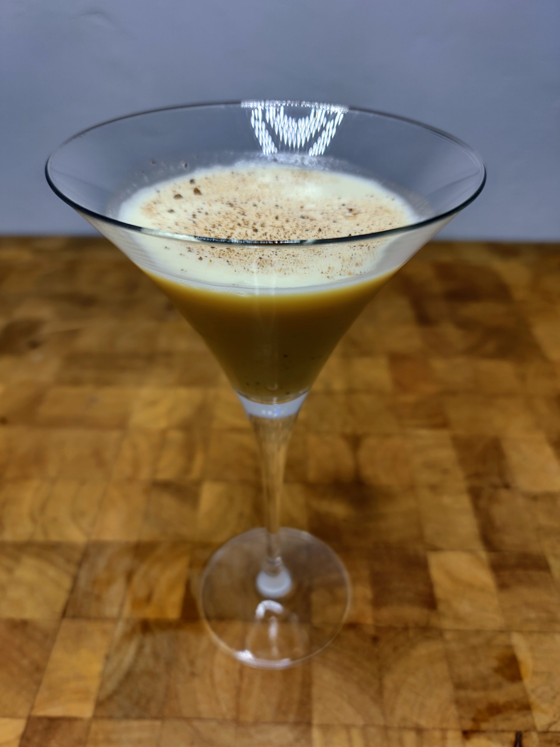 closeup of eggnog martini on a wooden table