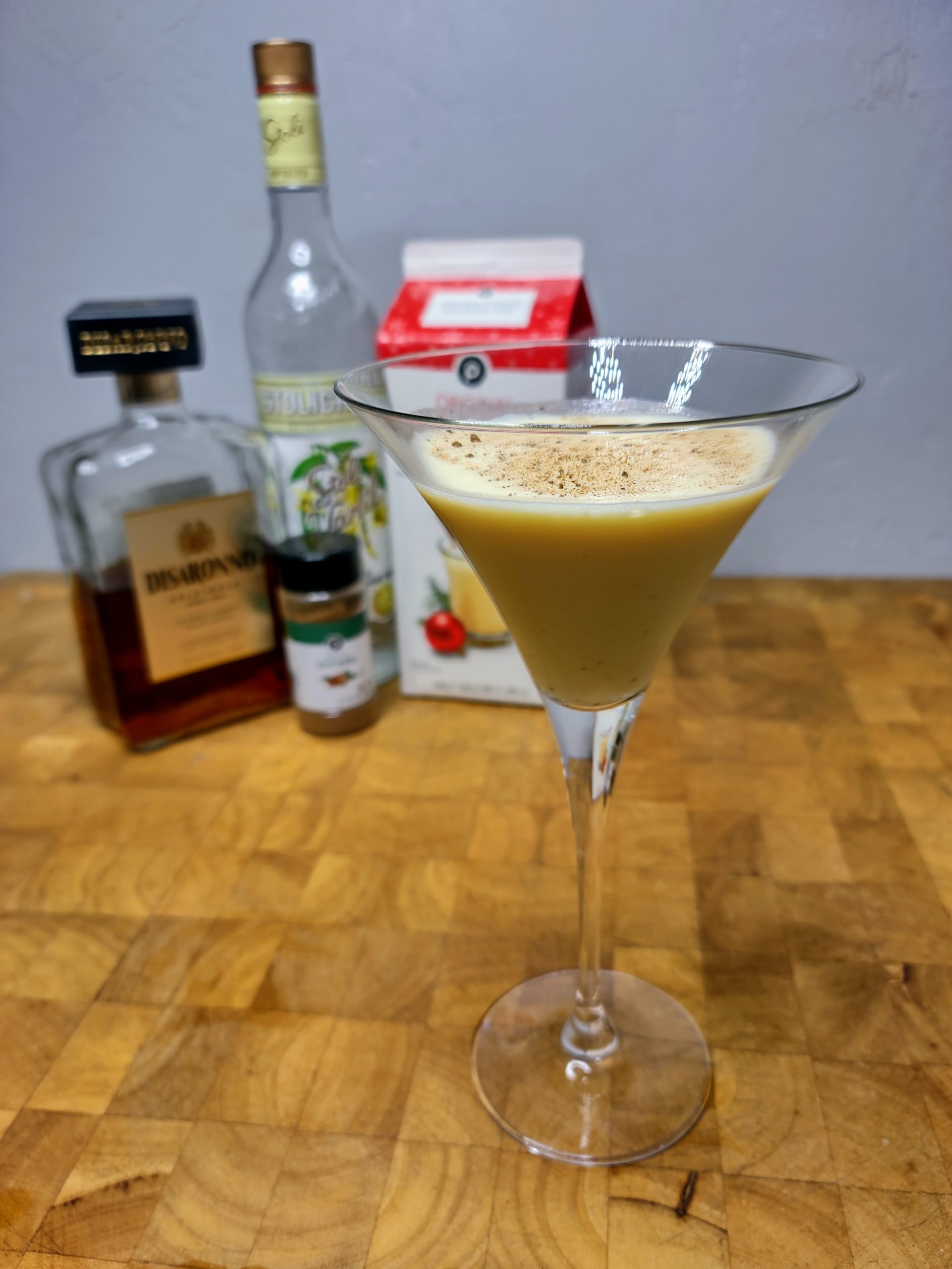 eggnog martini with ingredients in the background
