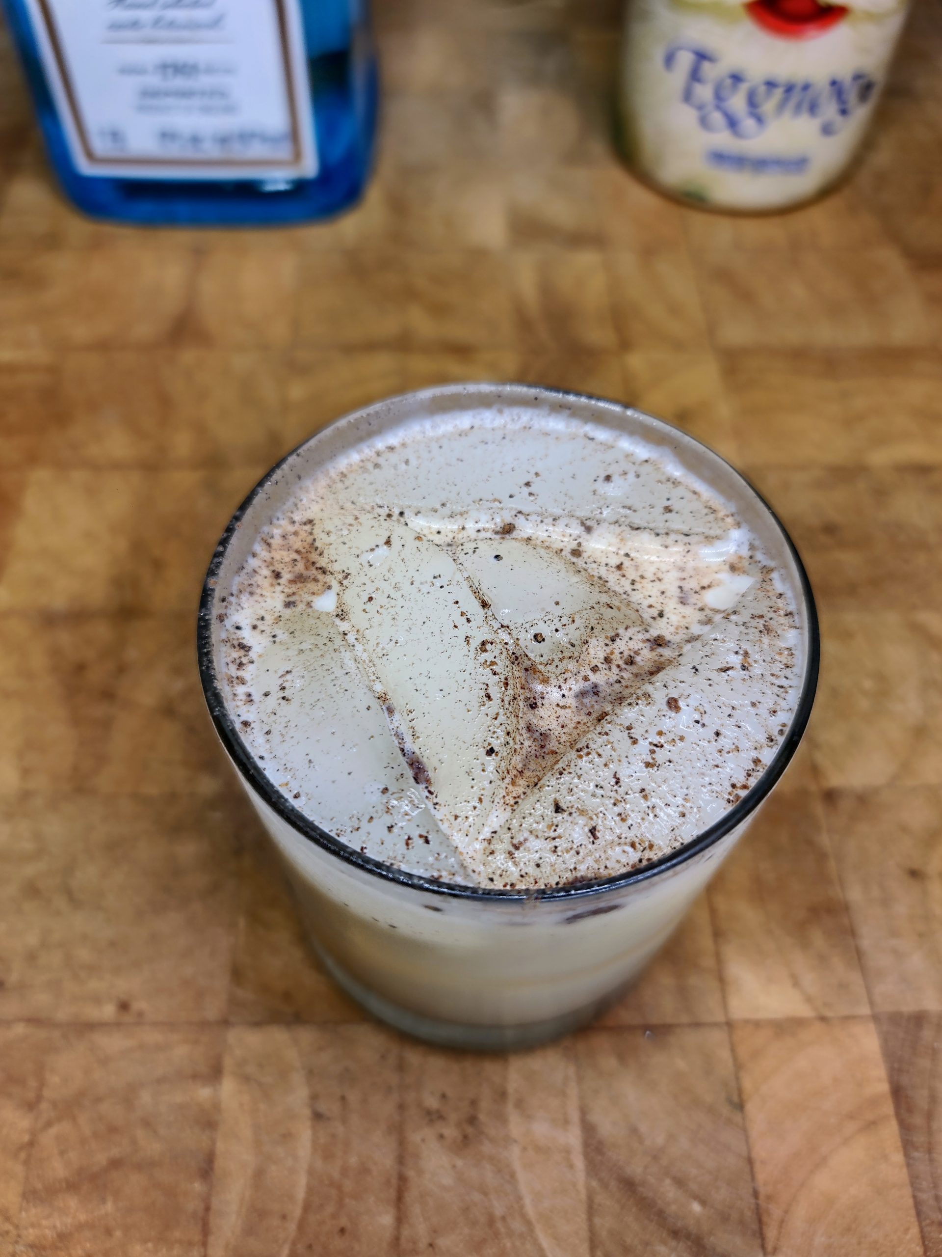 top down view of gin and eggnog with nutmeg on top of drink