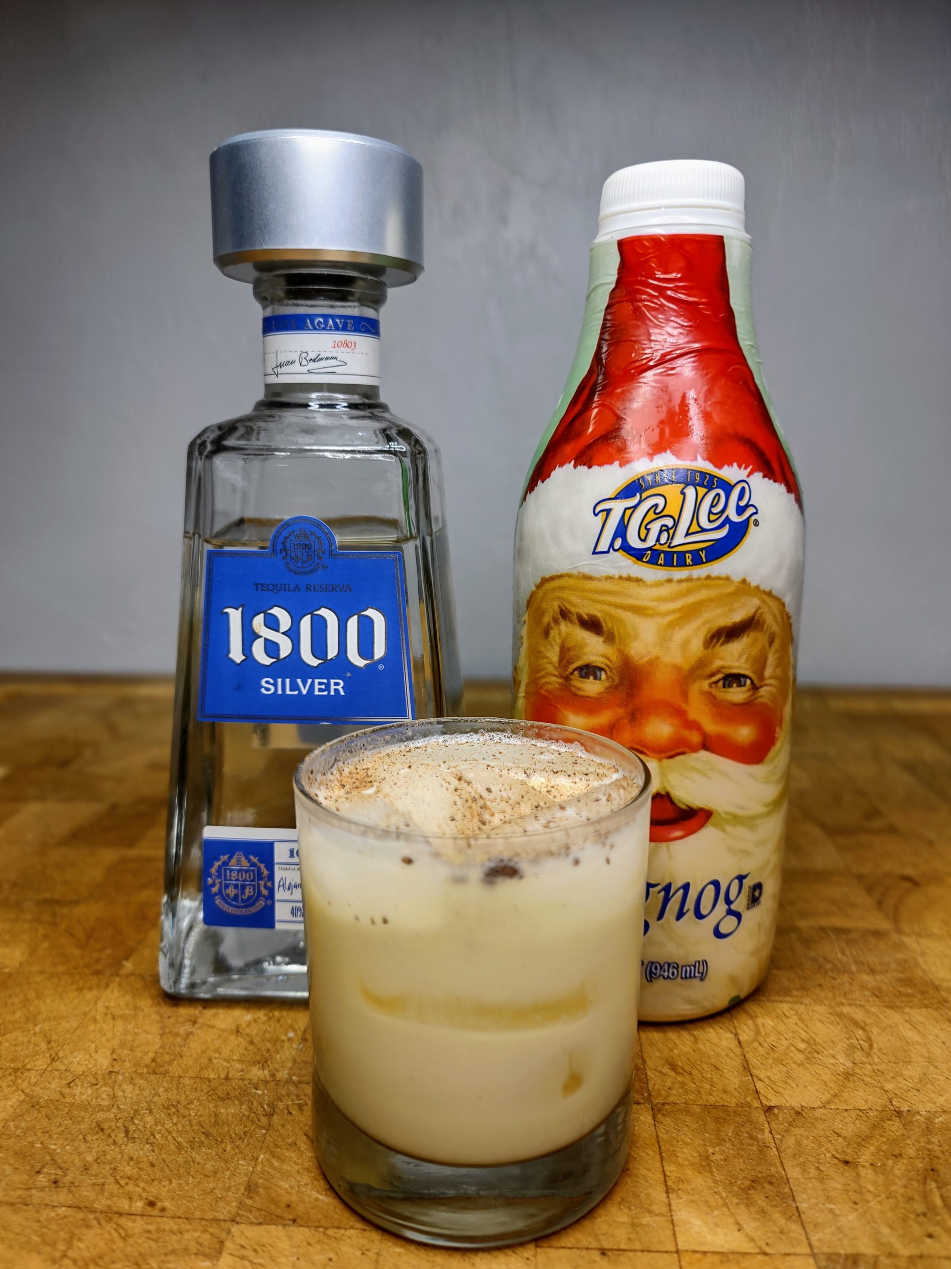 tequila and eggnog with ingredients next to the glass.
