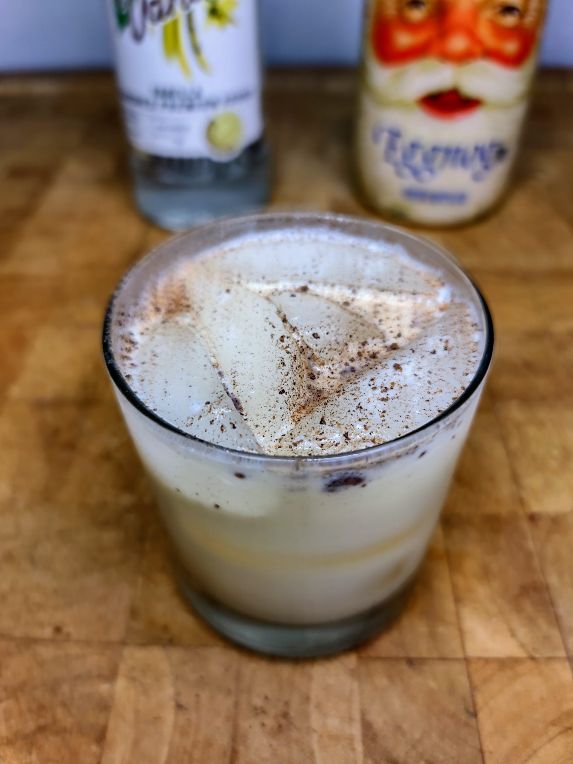 closeup of vodka and eggnog with nutmeg on top of drink