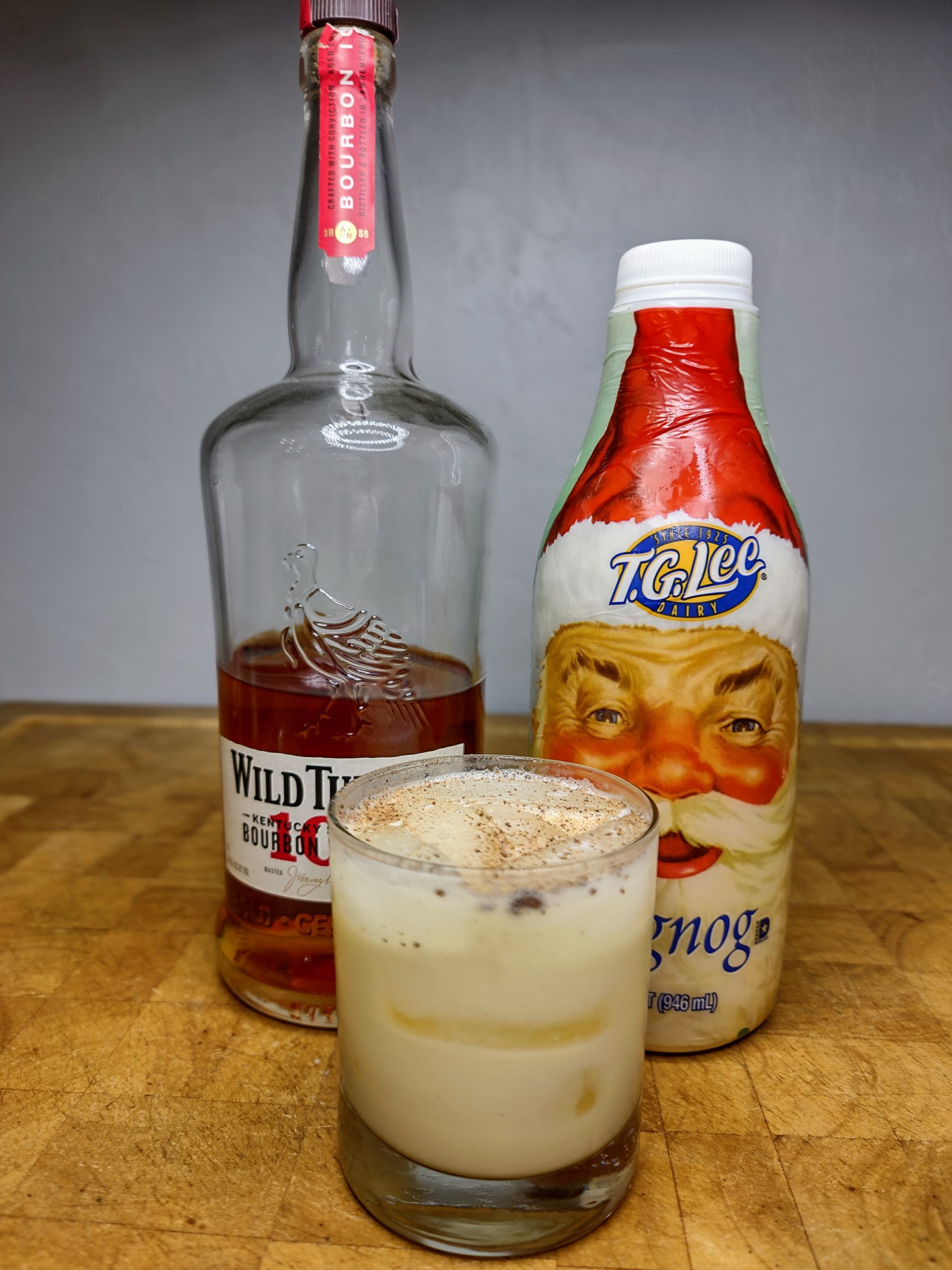 whiskey and eggnog in a rocks glass with ingredients next to it