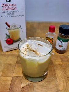 overhead view of fireball and eggnog with nutmeg on top with ingredients around the glass.