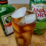 jager and ginger ale in a highball glass with ingredients behind the drink