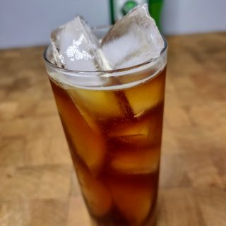 closeup of jager and mountain dew in a highball glass on a wooden table