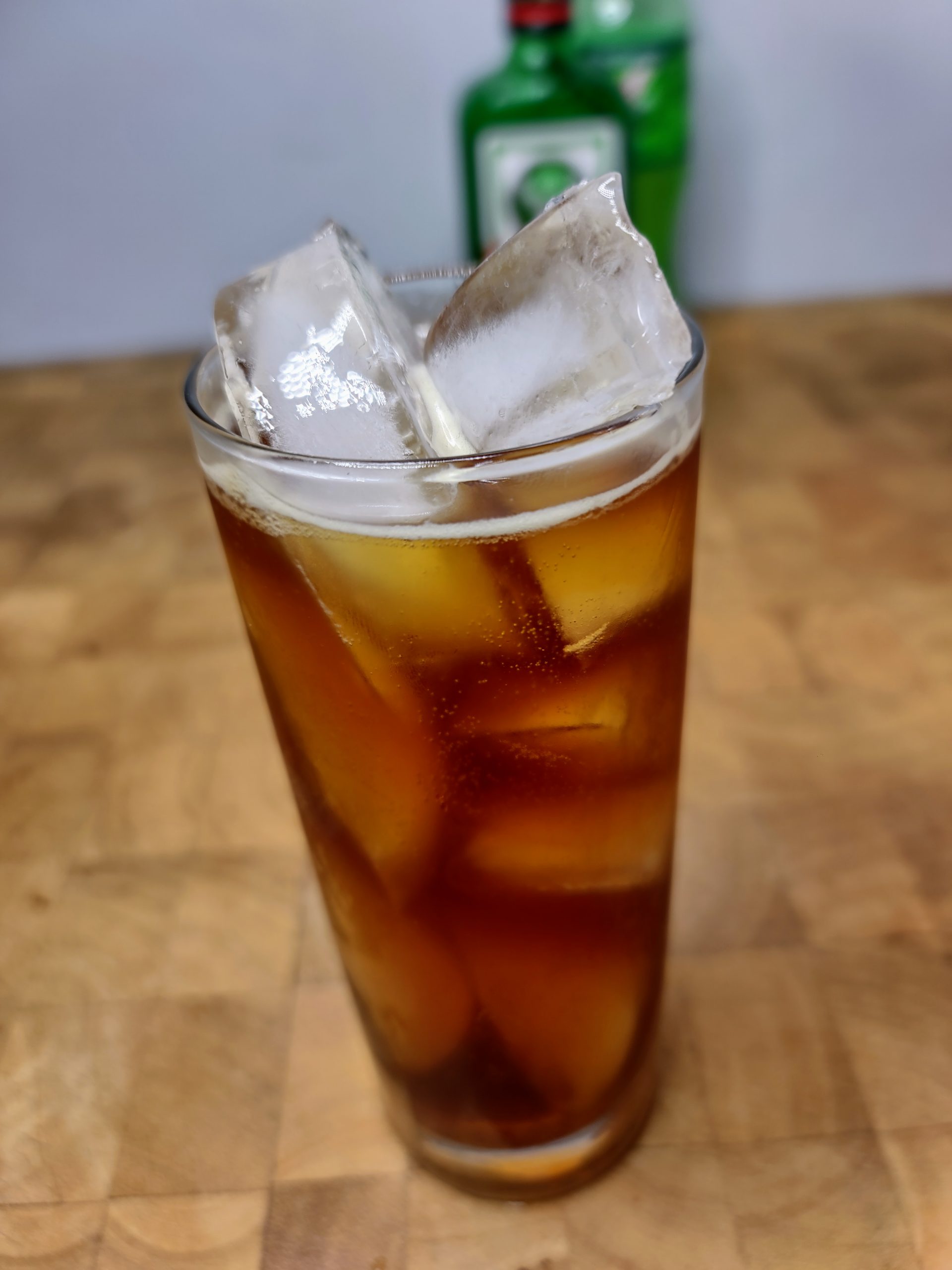 closeup of jager and mountain dew in a highball glass on a wooden table
