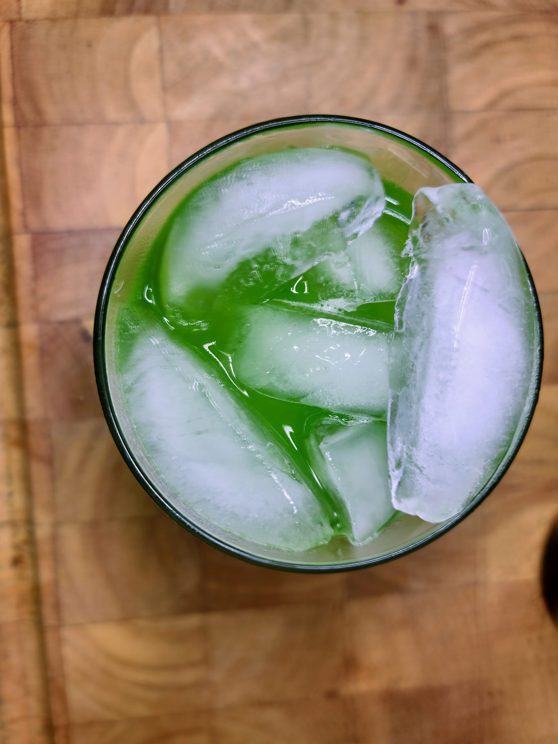 top down view of a midori sour on a wooden table