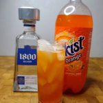vodka and orange soda with ingredients behind the glass