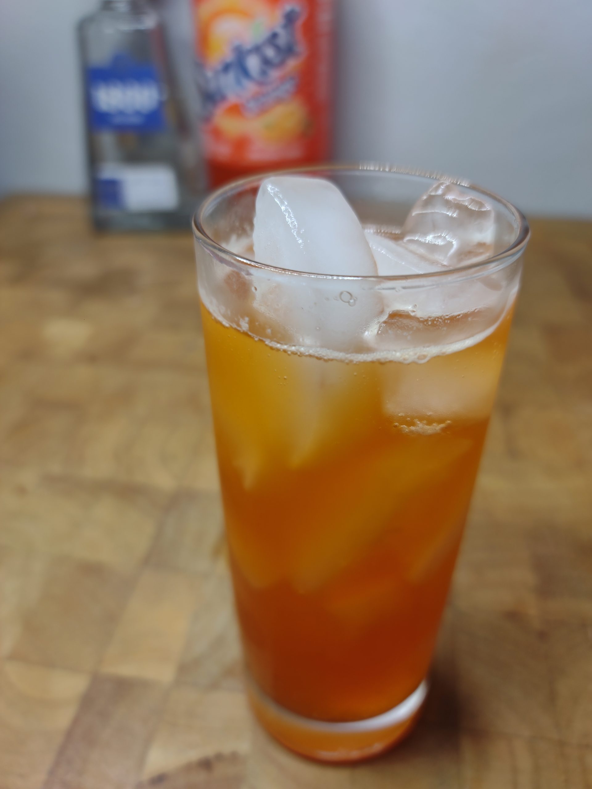 tequila and orange soda in a highball glass with ingredients in the background