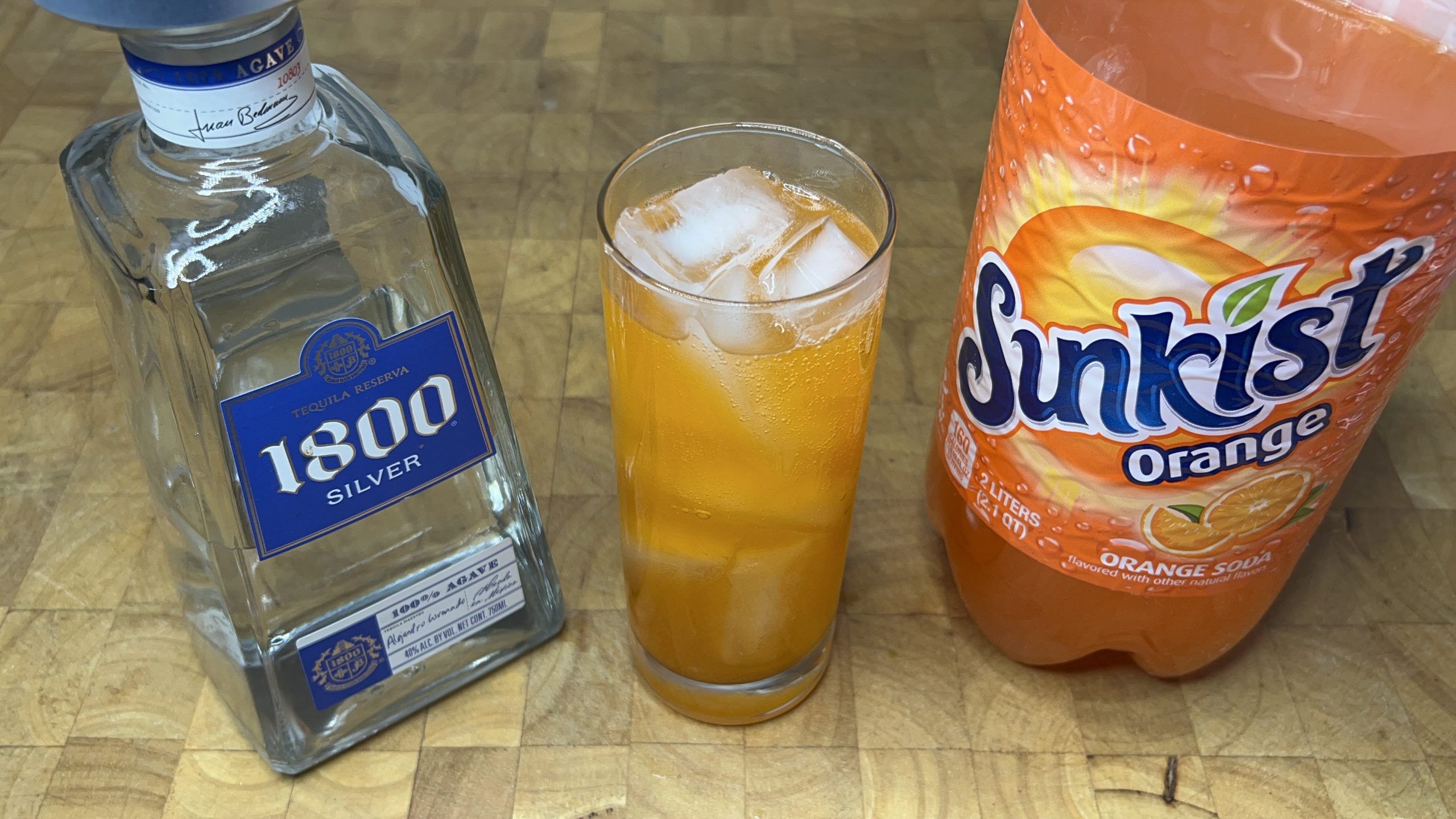 orange soda and vodka cocktail with ingredients next to the glass