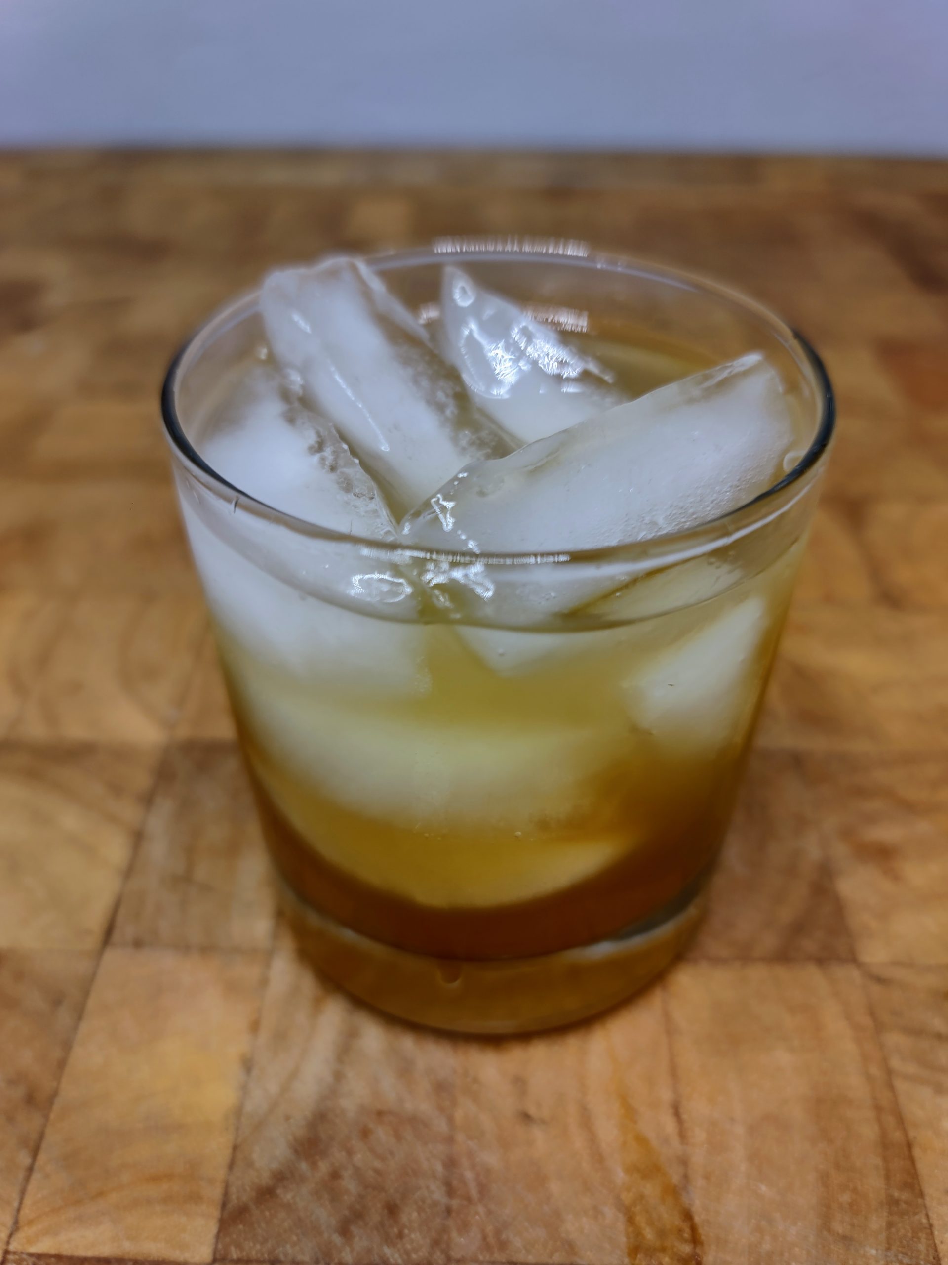 tequila and apple cider in a rocks glass on a wooden table