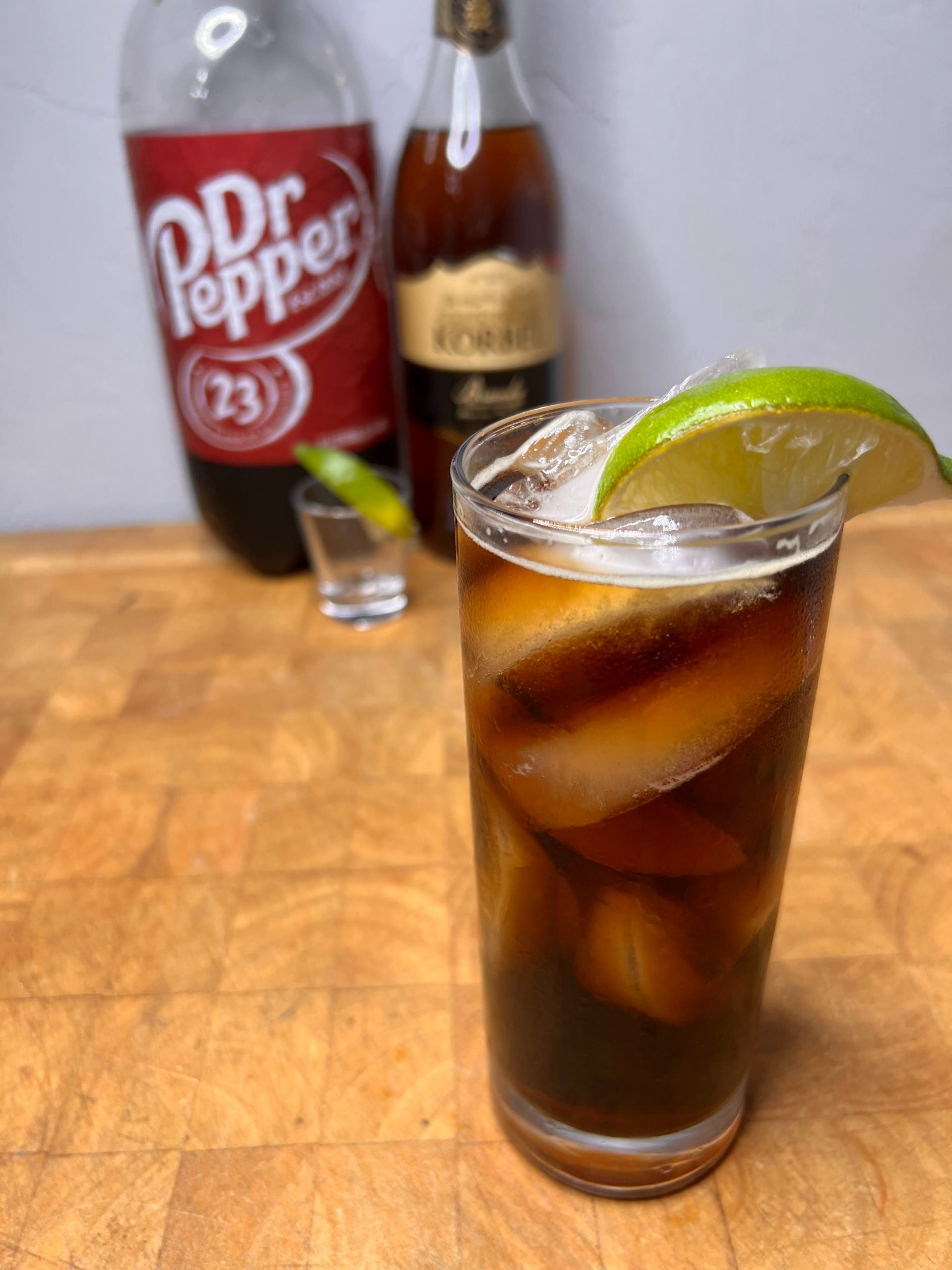 brandy and dr pepper with ingredients behind the drink