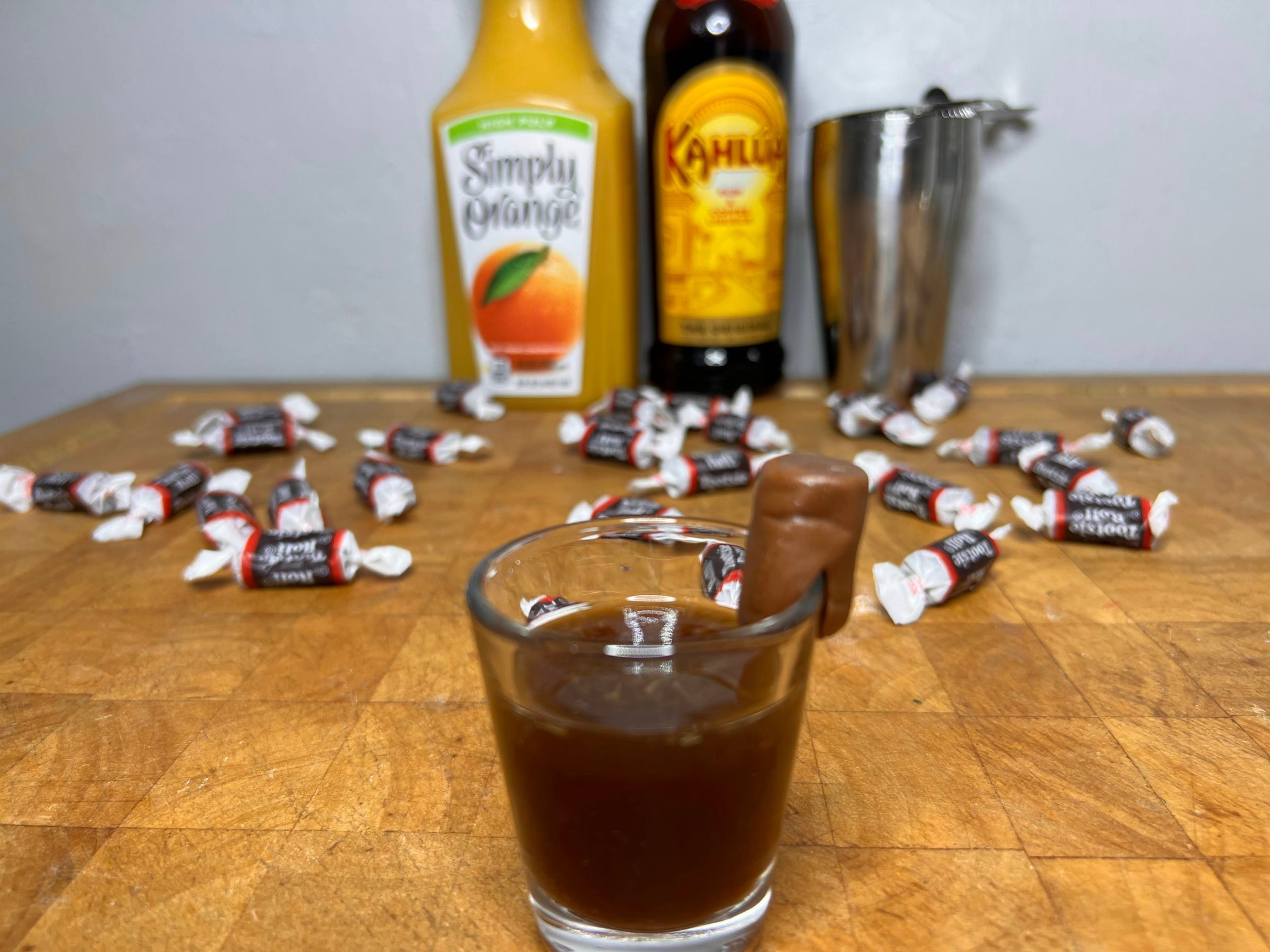 tootsie roll shot with ingredients behind the glass.