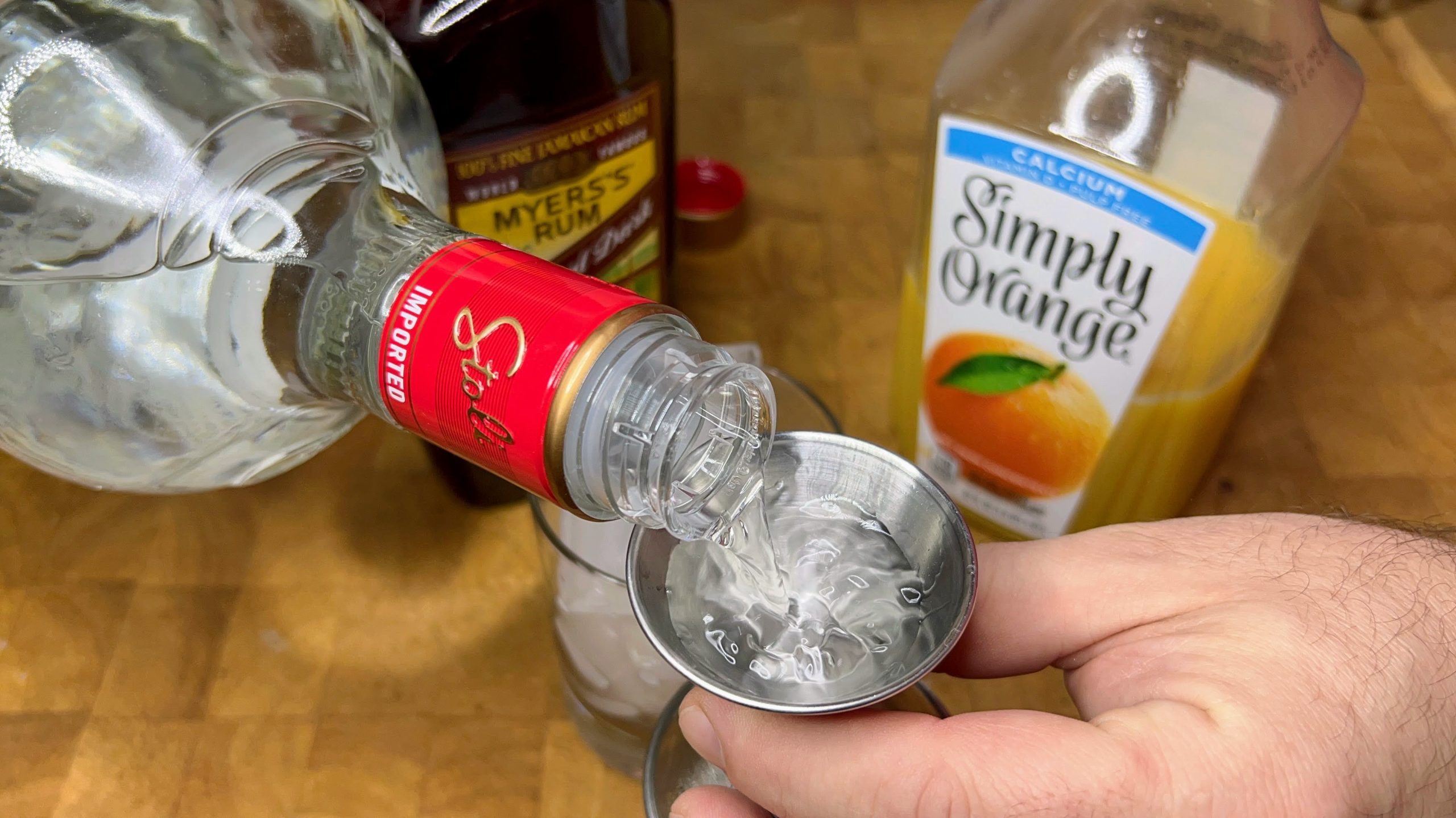 measuring out vodka with a jigger