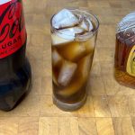 crown and coke in a highball glass with ingredients next to the glass