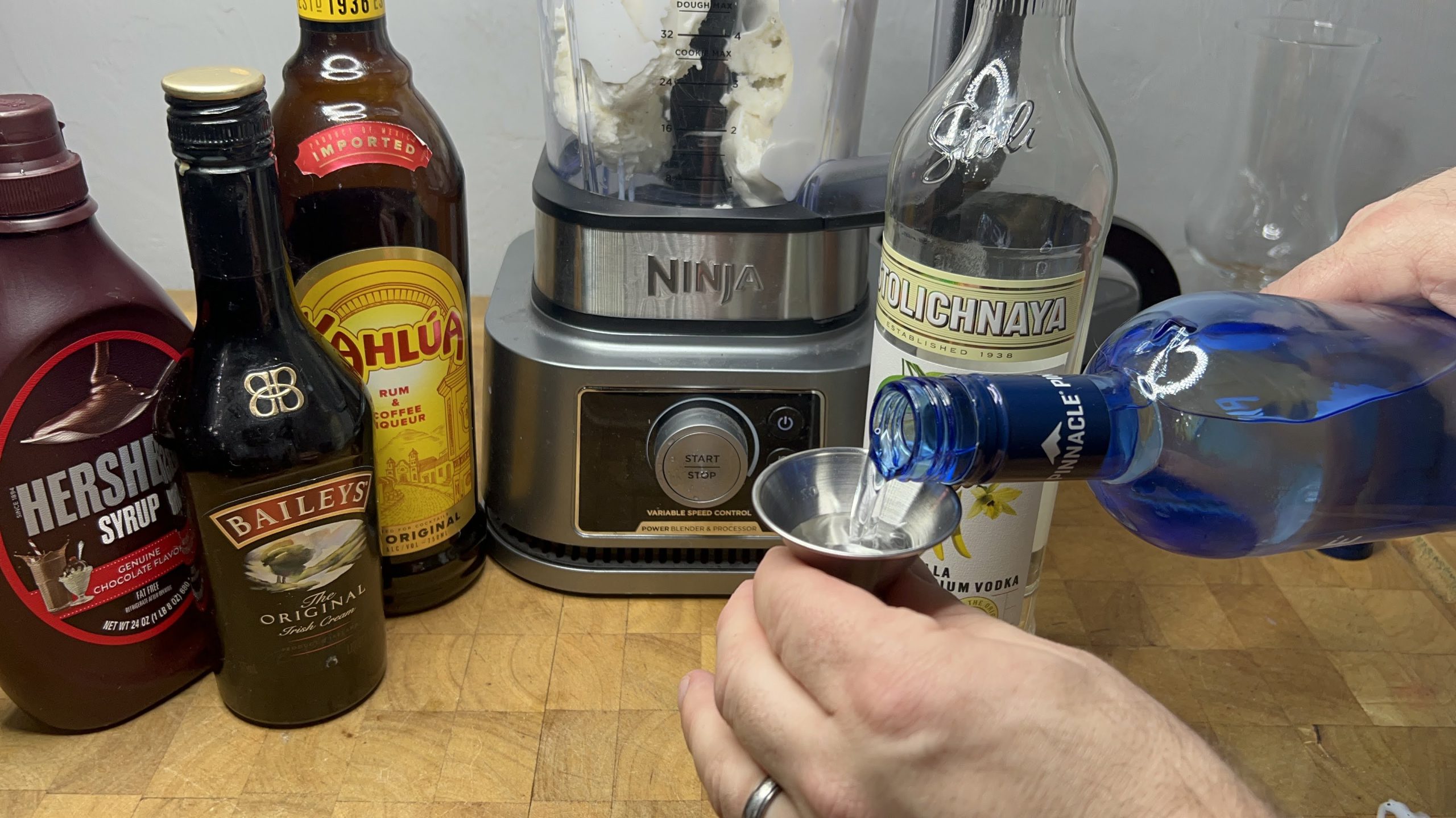 measuring whipped cream vodka with a jigger
