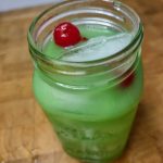 closeup or irish wake drink in a mason jar with cherry garnish