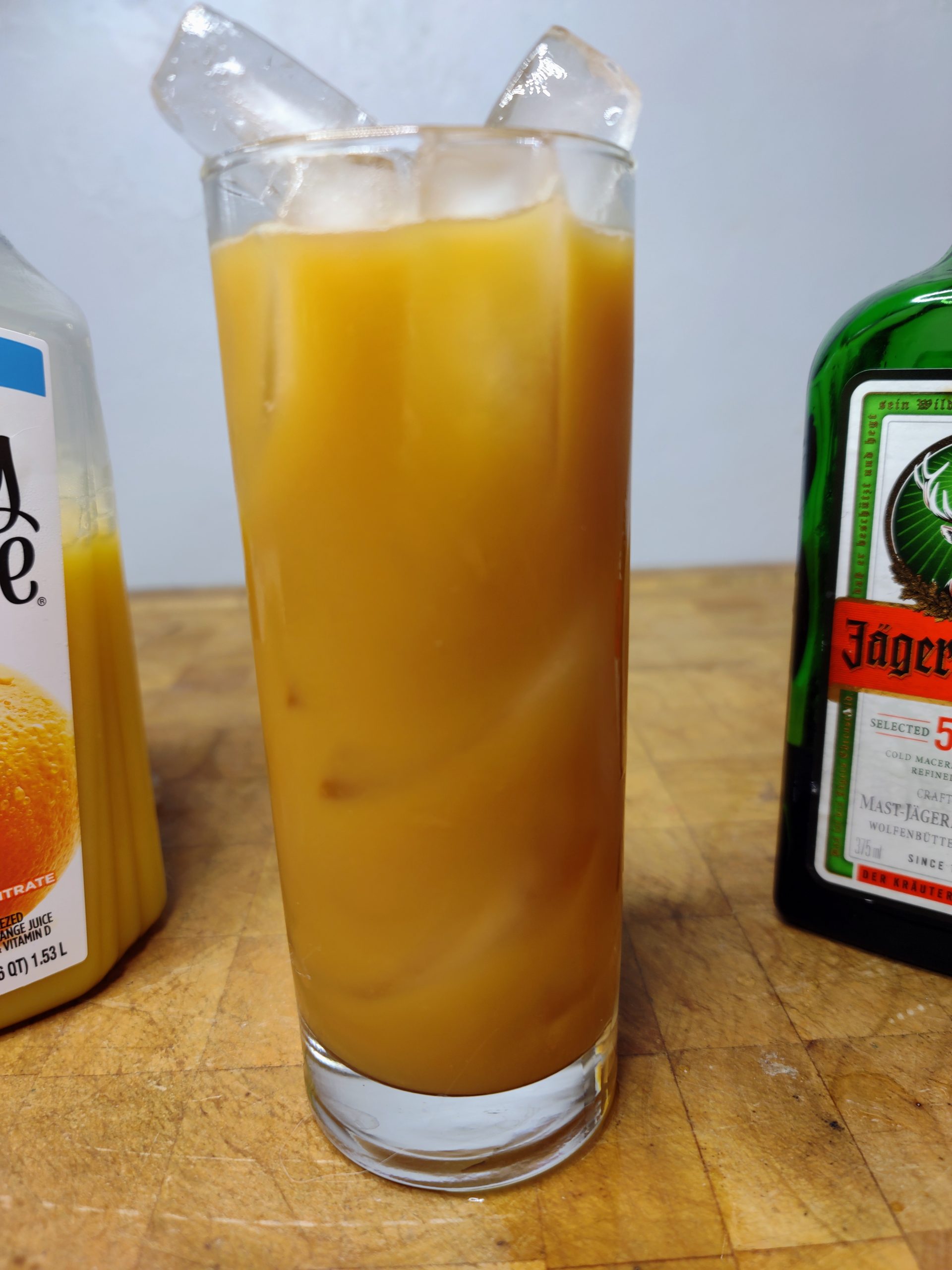 jager and orange juice in a highaball glass on a wooden table