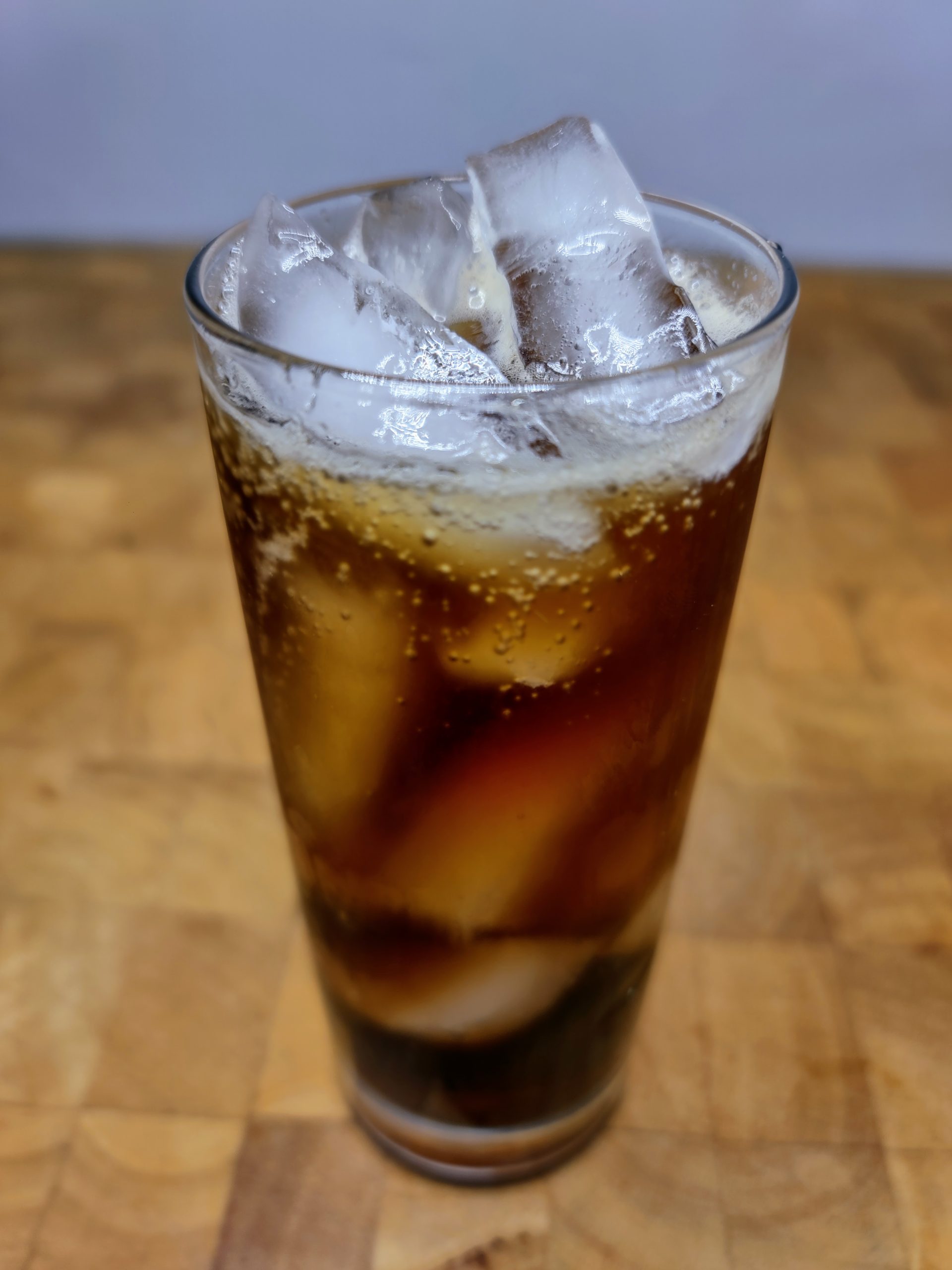 highball glass filled with jameson and coke on a wooden table