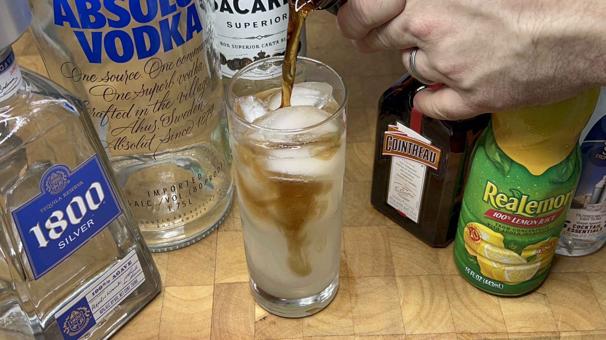pouring coke into a highball glass.