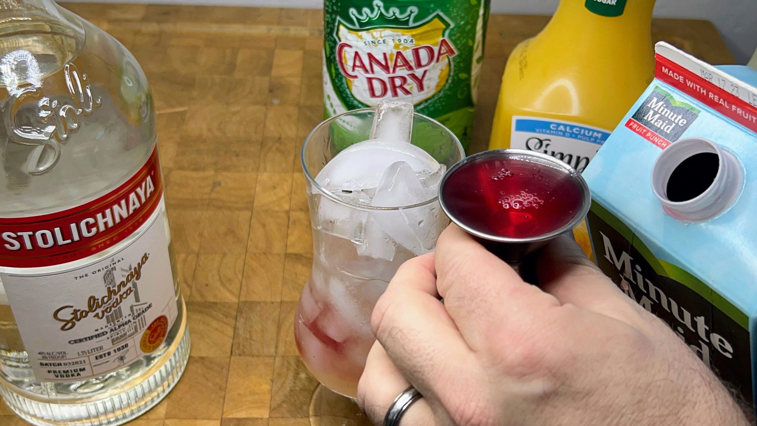 measuring out fruit punch with a jigger