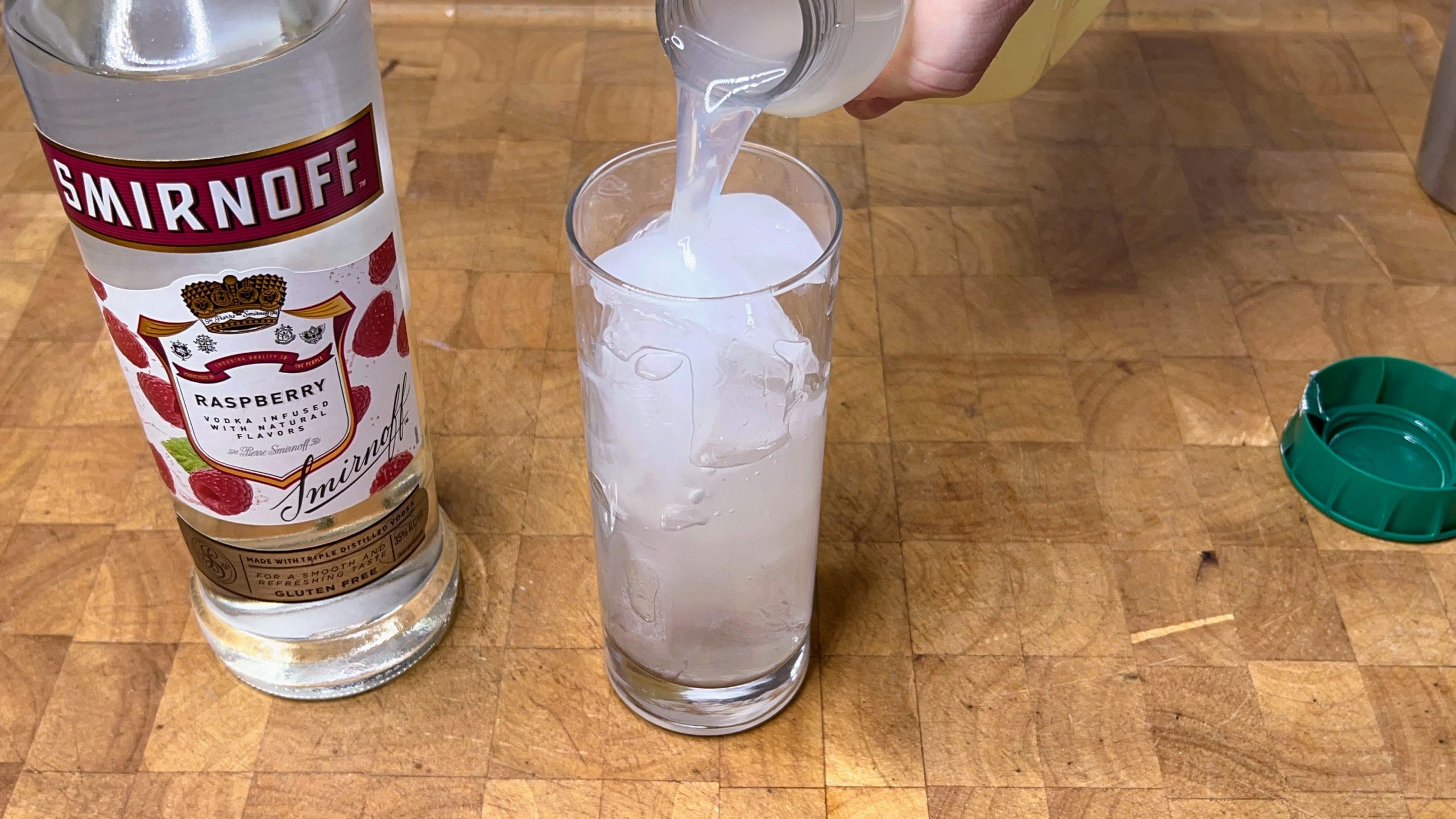 pouring lemonade into a highball glass