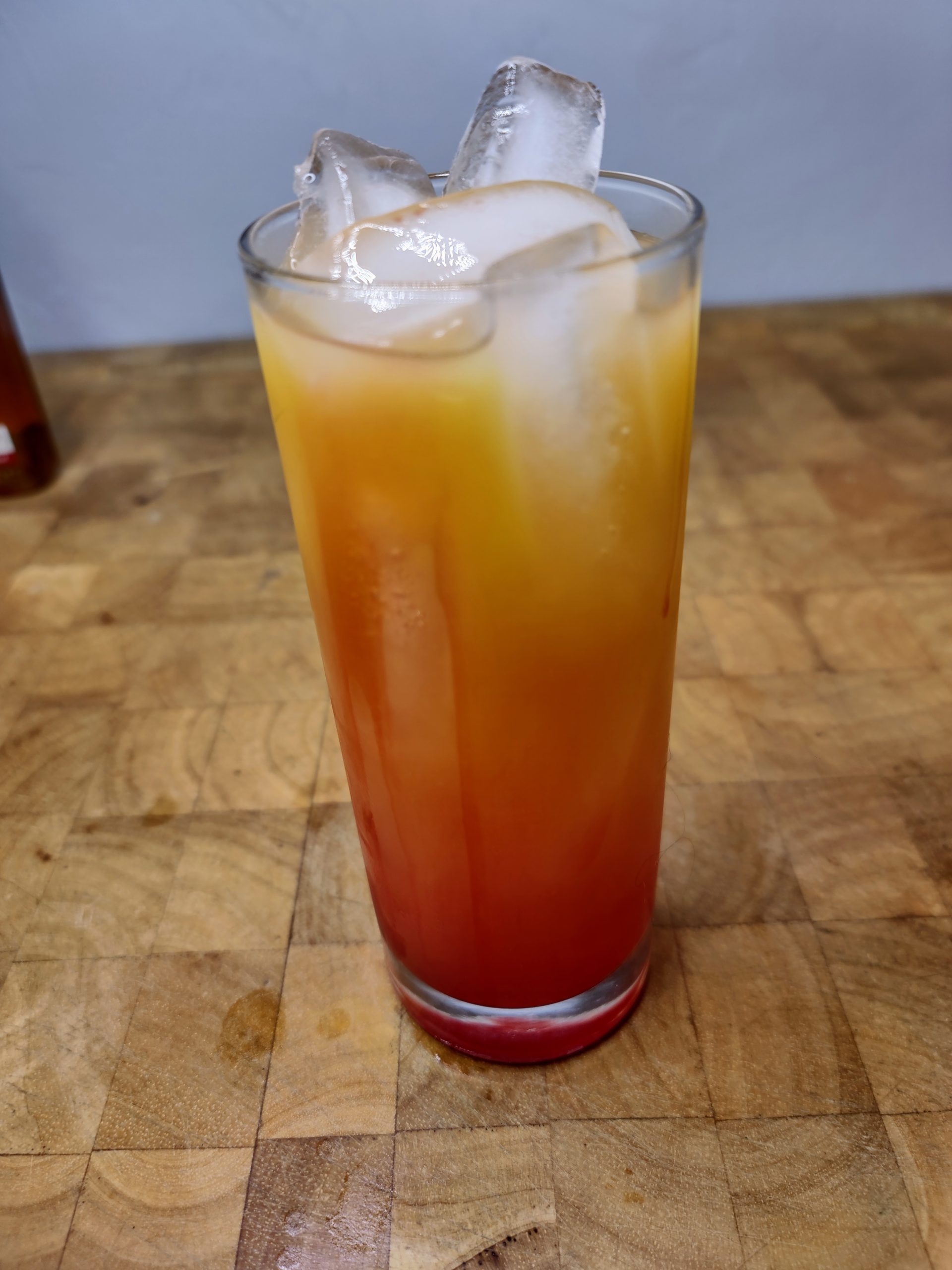 closeup of a georgia peach cocktail in a highball glass on a wooden table