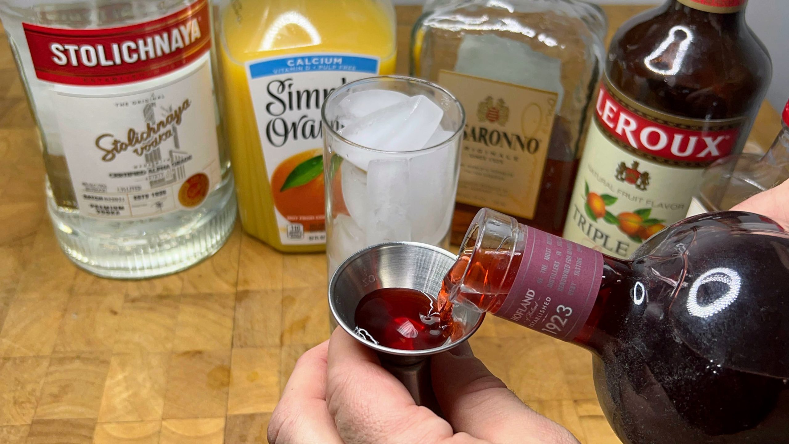 pouring sloe gin in a jigger