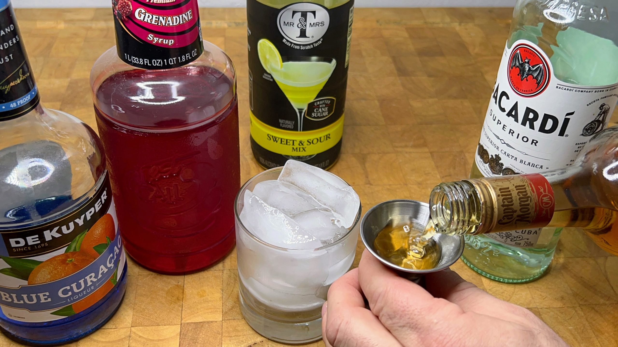 measuring spiced rum in a jigger