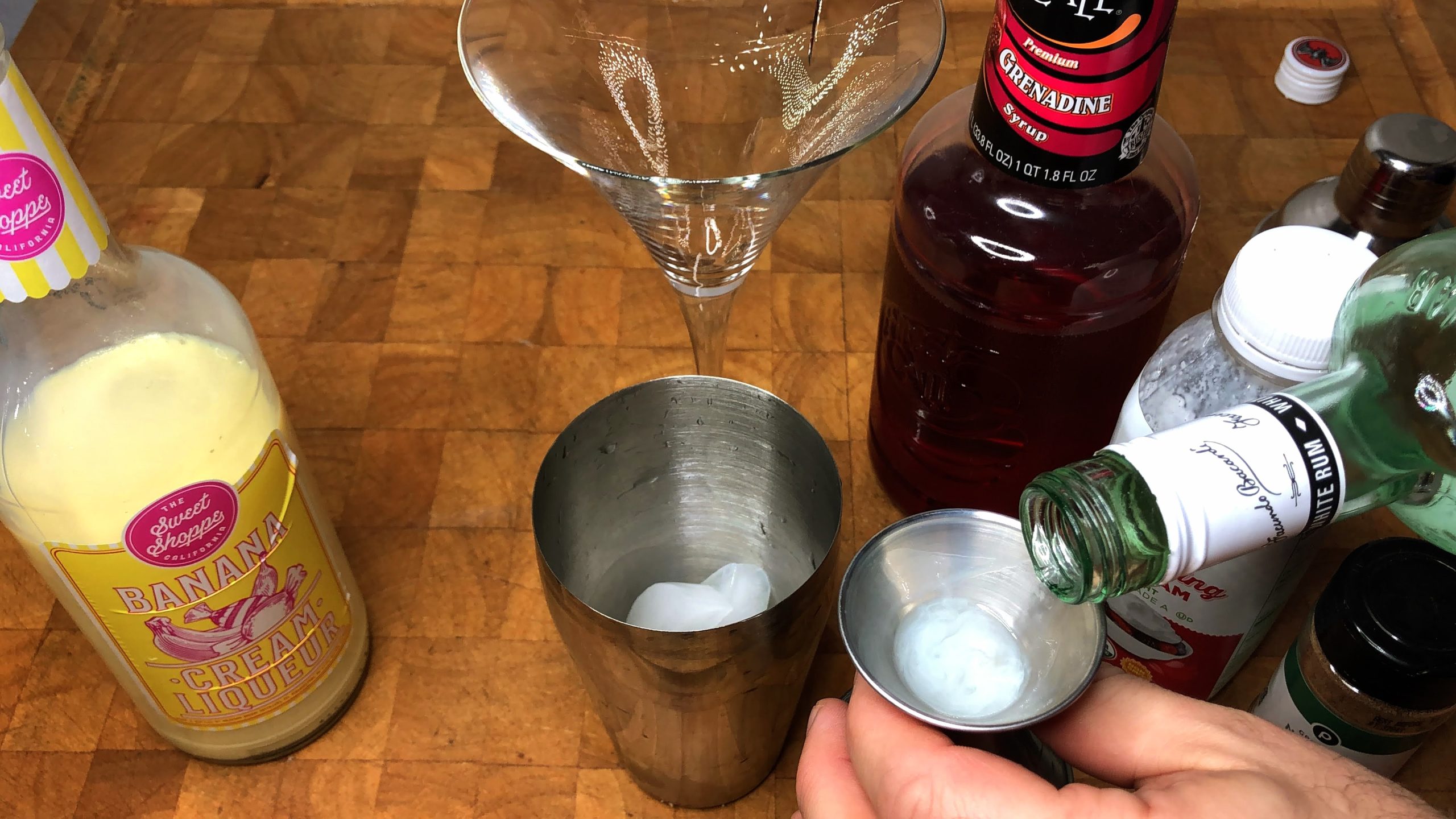 measuring white rum with a jigger