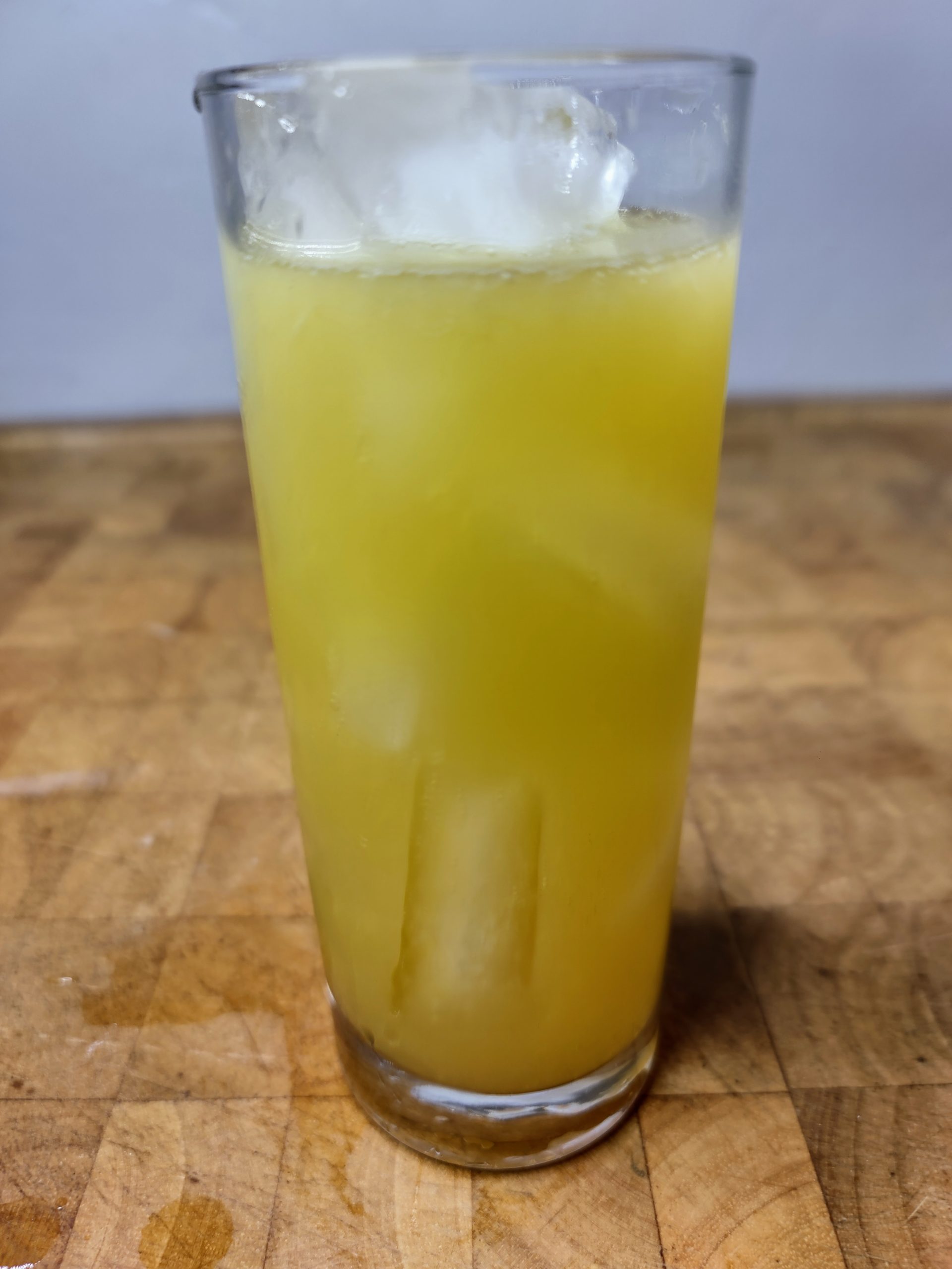 closeup of black eyed susan cocktail on a wooden table