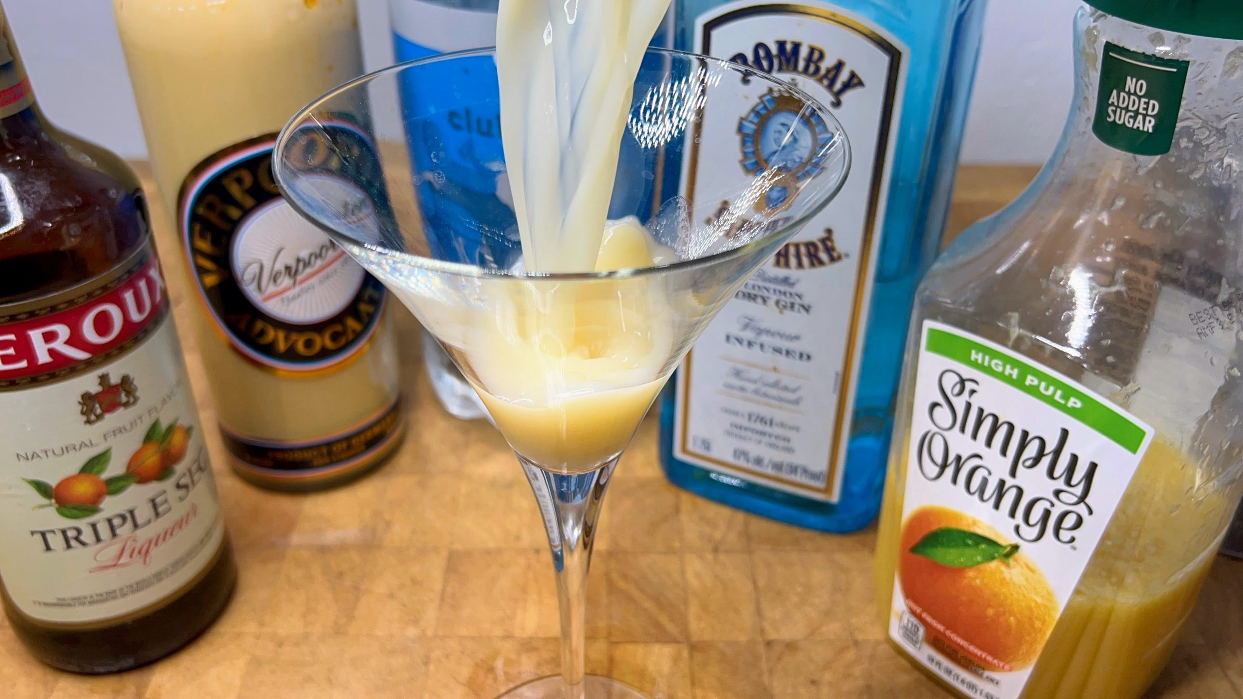 pouring fluffy duck cocktail into a martini glass