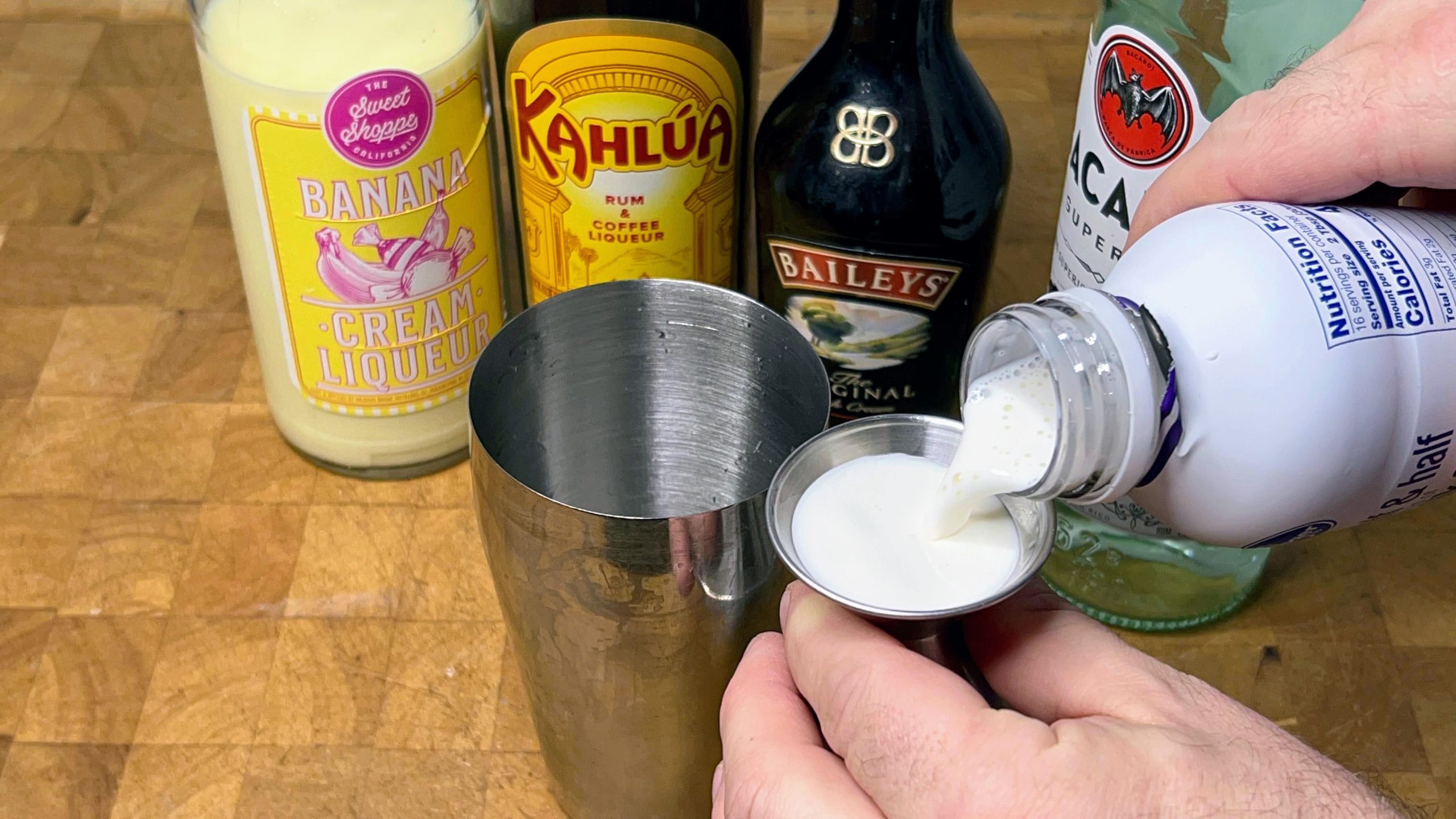 pouring half and half out into a jigger