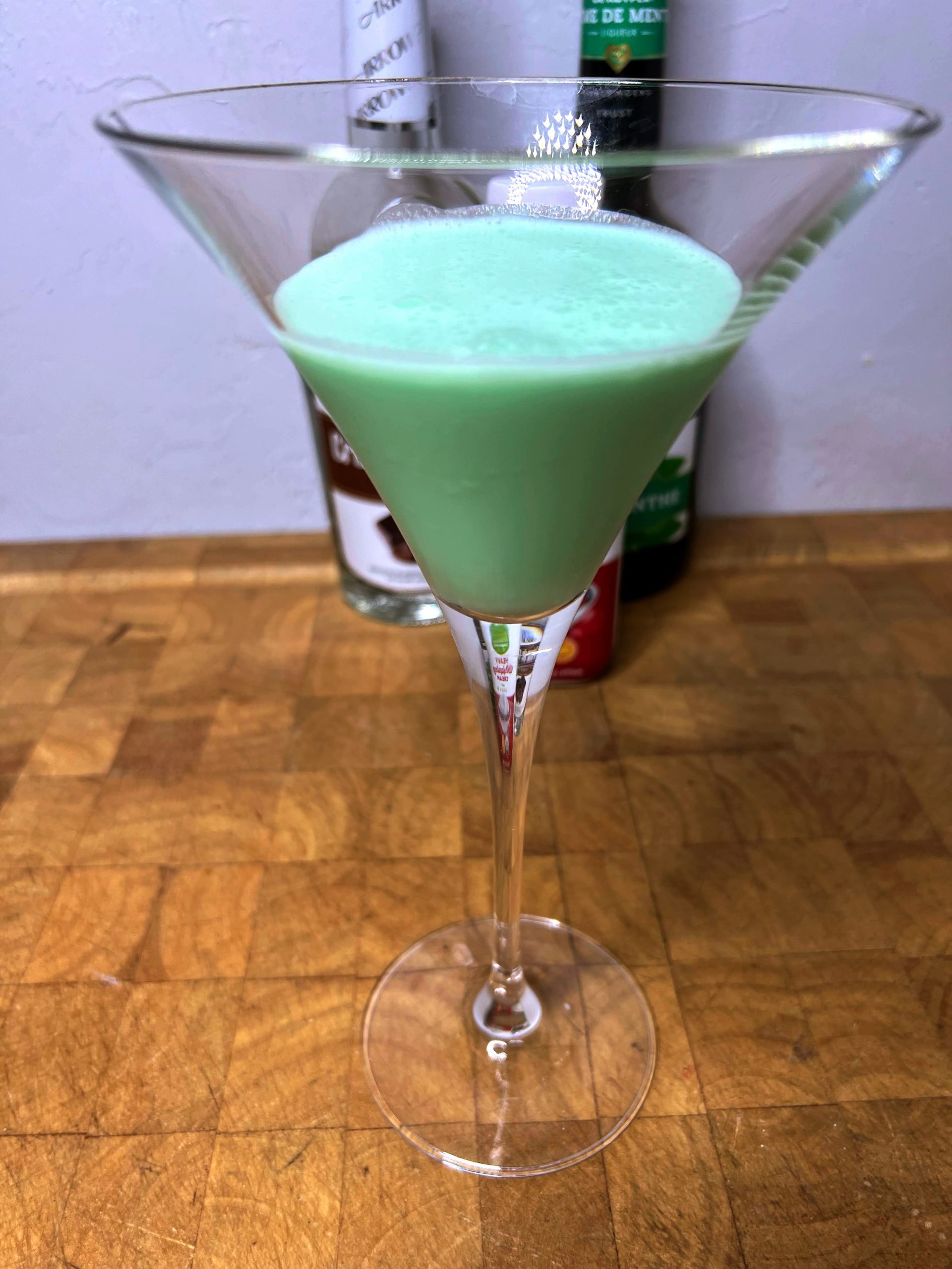 closeup of grasshopper drink in a martini glass on a wooden table