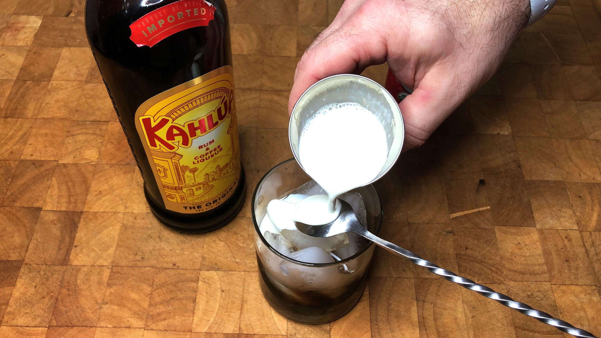 pouring heavy cream over the back of a bar spoon