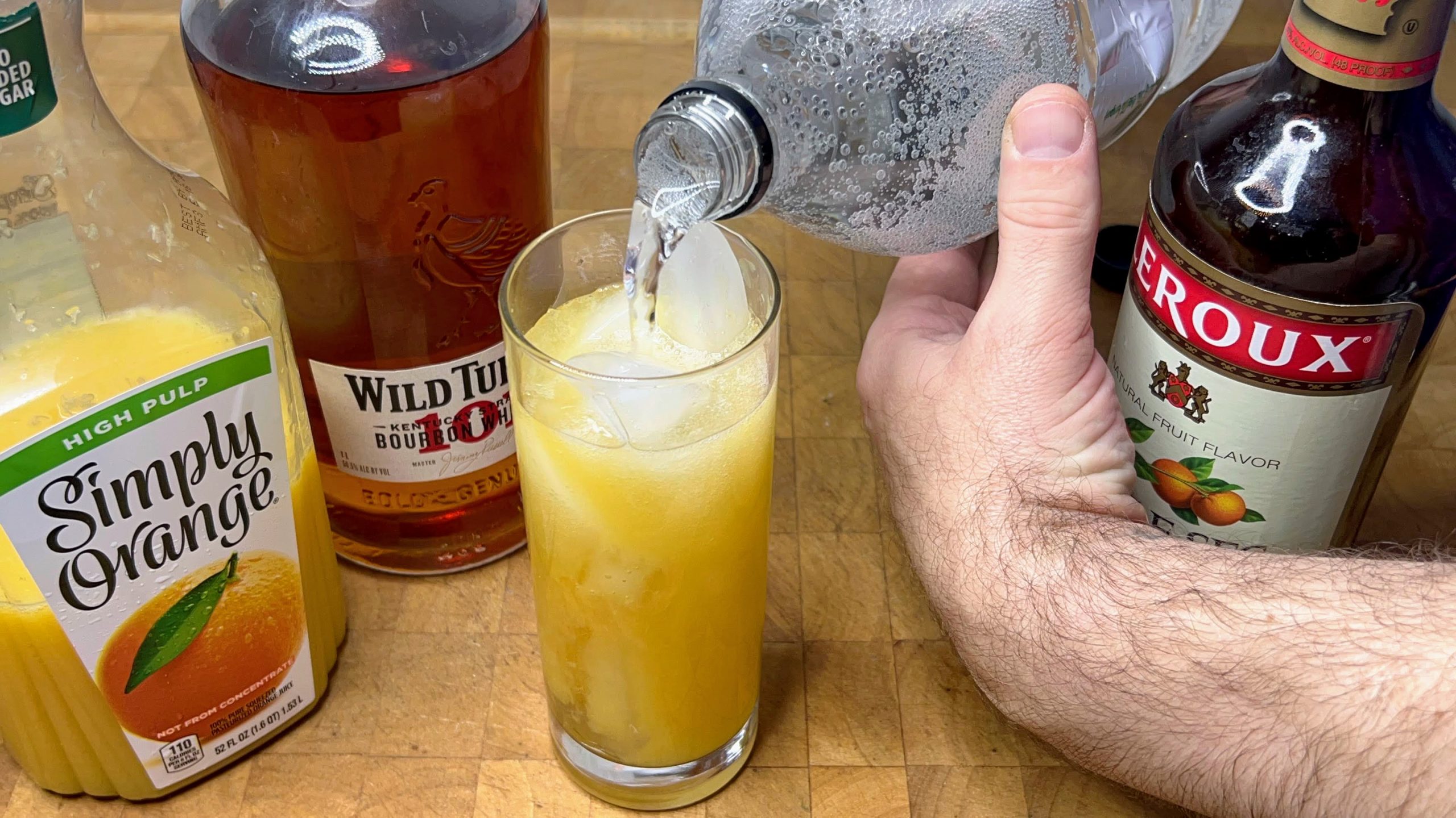 pouring sprite into a highball glass