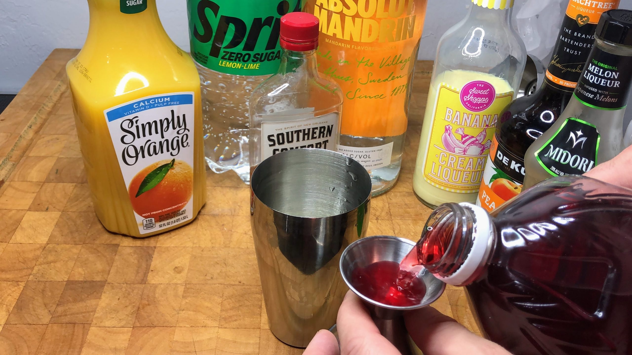 measuring cranberry juice with jigger