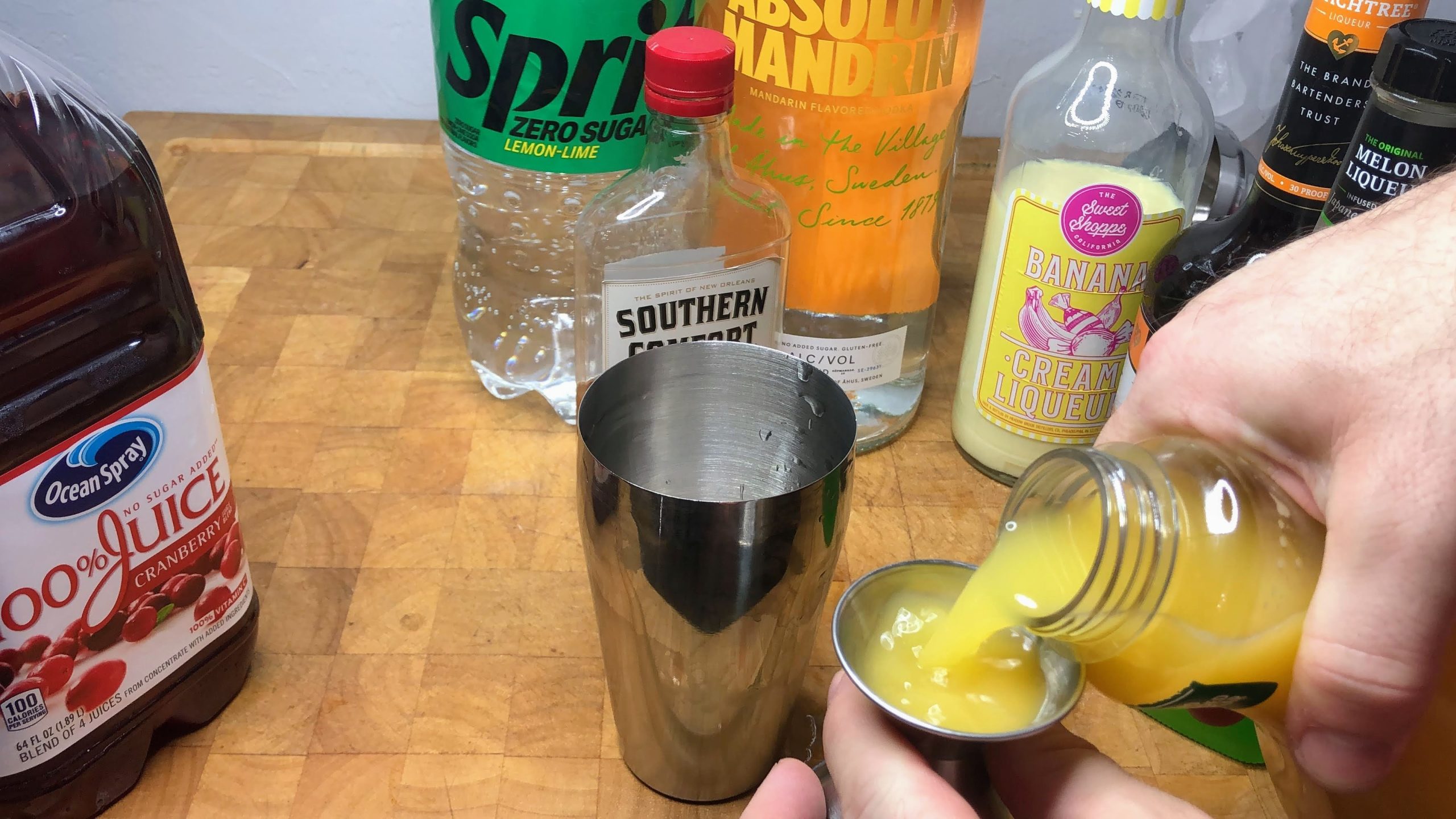 measuring orange juice with jigger