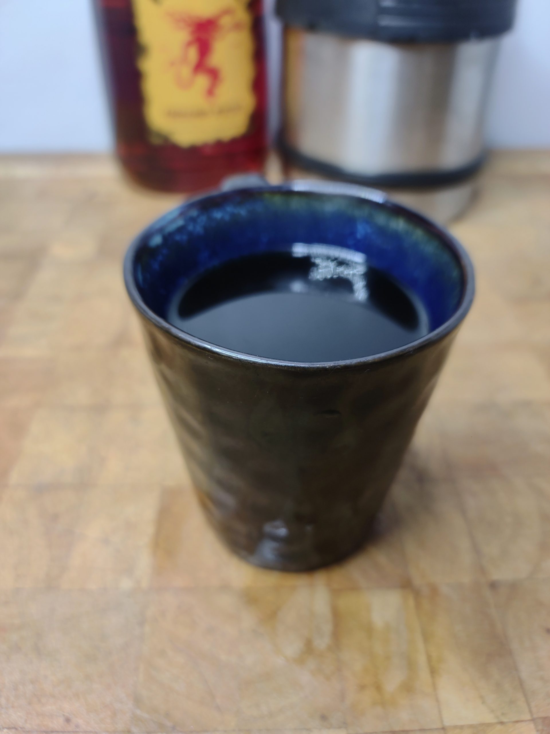 fireball coffee in a mug on a wooden table with ingredients in the background